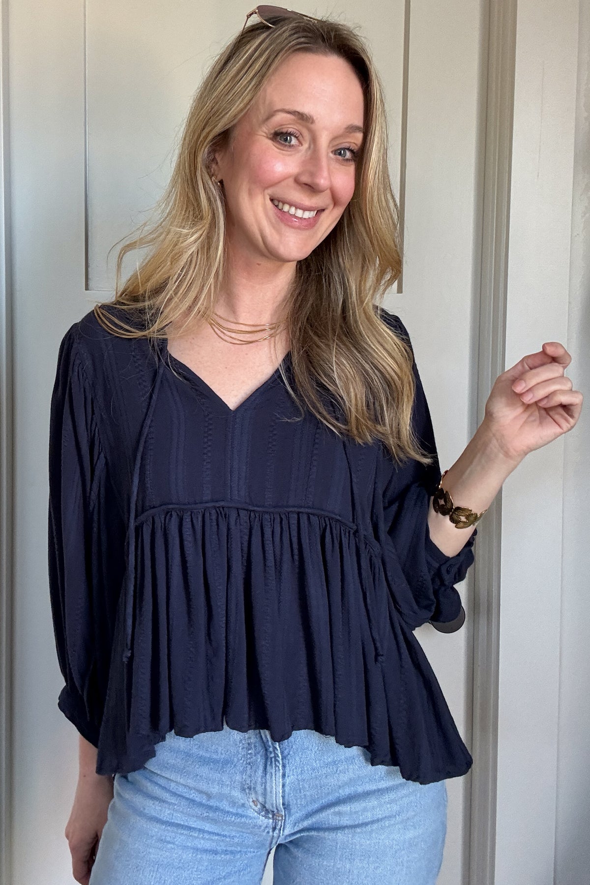 The Billowy Navy Textured Knit Blouse is a gorgeous, heavyweight piece that drapes beautifully and feels incredible on. It features a rich, deep navy hue with a subtle textured pattern, adding dimension to its effortless style. The relaxed fit is enhanced by a flattering V-neckline and delicate tie details. Voluminous sleeves with gathered cuffs add a touch of femininity, while the flowy, tiered silhouette gives it a chic, elevated look. Perfect for pairing with denim for an easy, stylish outfit.