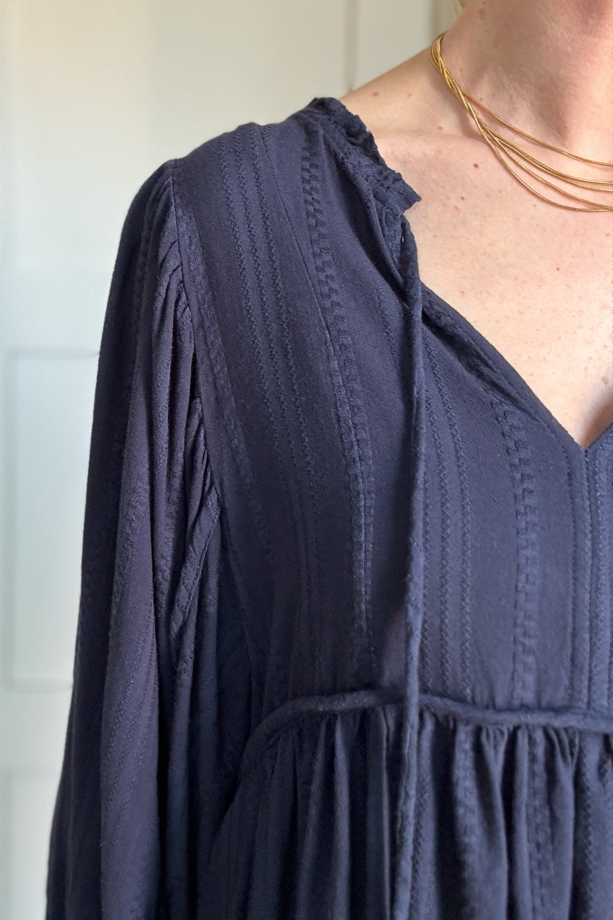 The Billowy Navy Textured Knit Blouse is a gorgeous, heavyweight piece that drapes beautifully and feels incredible on. It features a rich, deep navy hue with a subtle textured pattern, adding dimension to its effortless style. The relaxed fit is enhanced by a flattering V-neckline and delicate tie details. Voluminous sleeves with gathered cuffs add a touch of femininity, while the flowy, tiered silhouette gives it a chic, elevated look. Perfect for pairing with denim for an easy, stylish outfit.