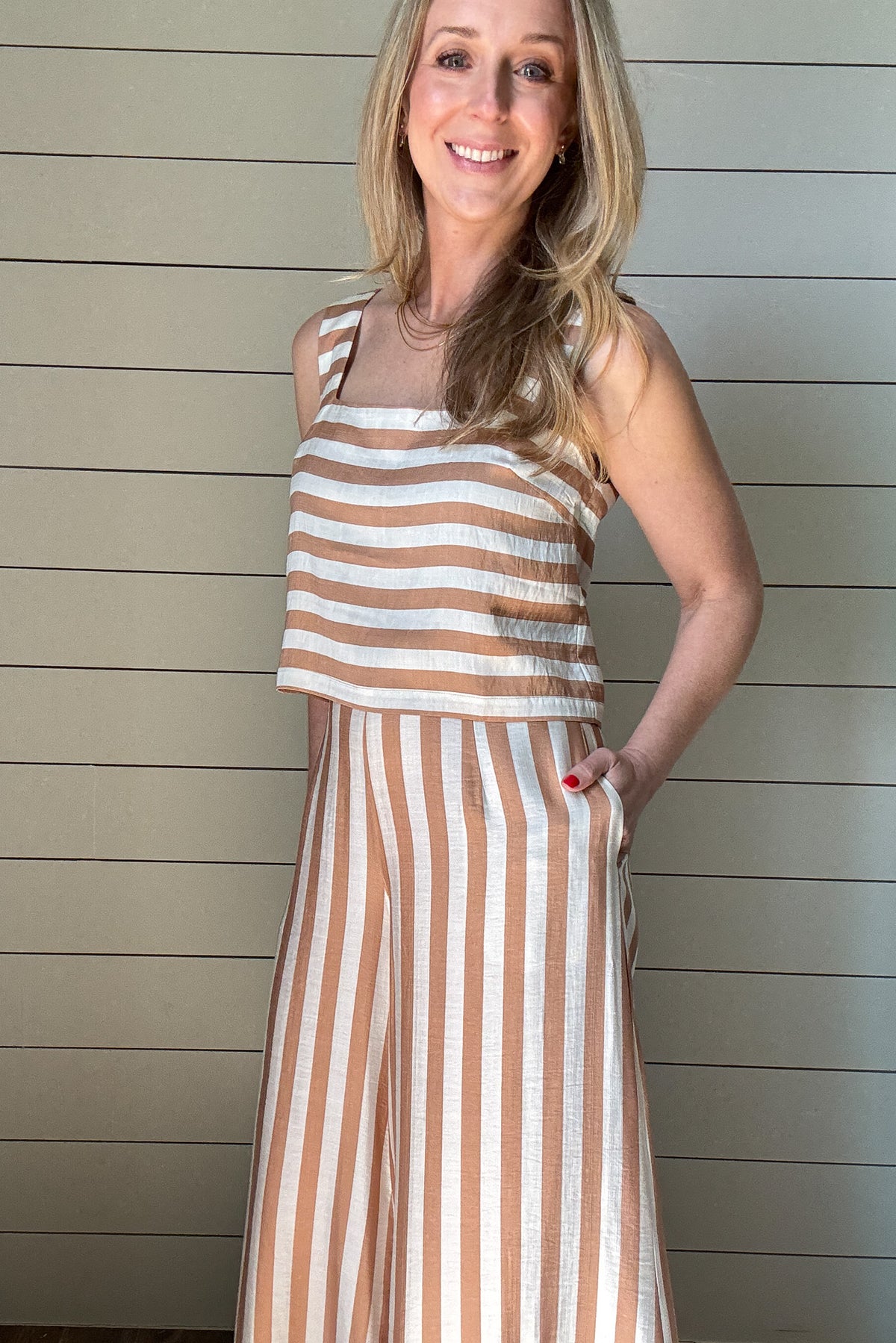 Effortless, breezy, and oh so fun! These full-length billowy pants from Traffic People bring all the flow with their vertical tan and cream stripes, side zipper, flattering flat front waistband, and comfy elastic back. They’ve got pockets (because who doesn’t love pockets?) and a soft lining for easy wear.
They pair with the striped shell top for a playful twist—horizontal stripes, a sleek square neckline, and a slip on design make it the perfect match. A little boho, a little classic, and totally effortle