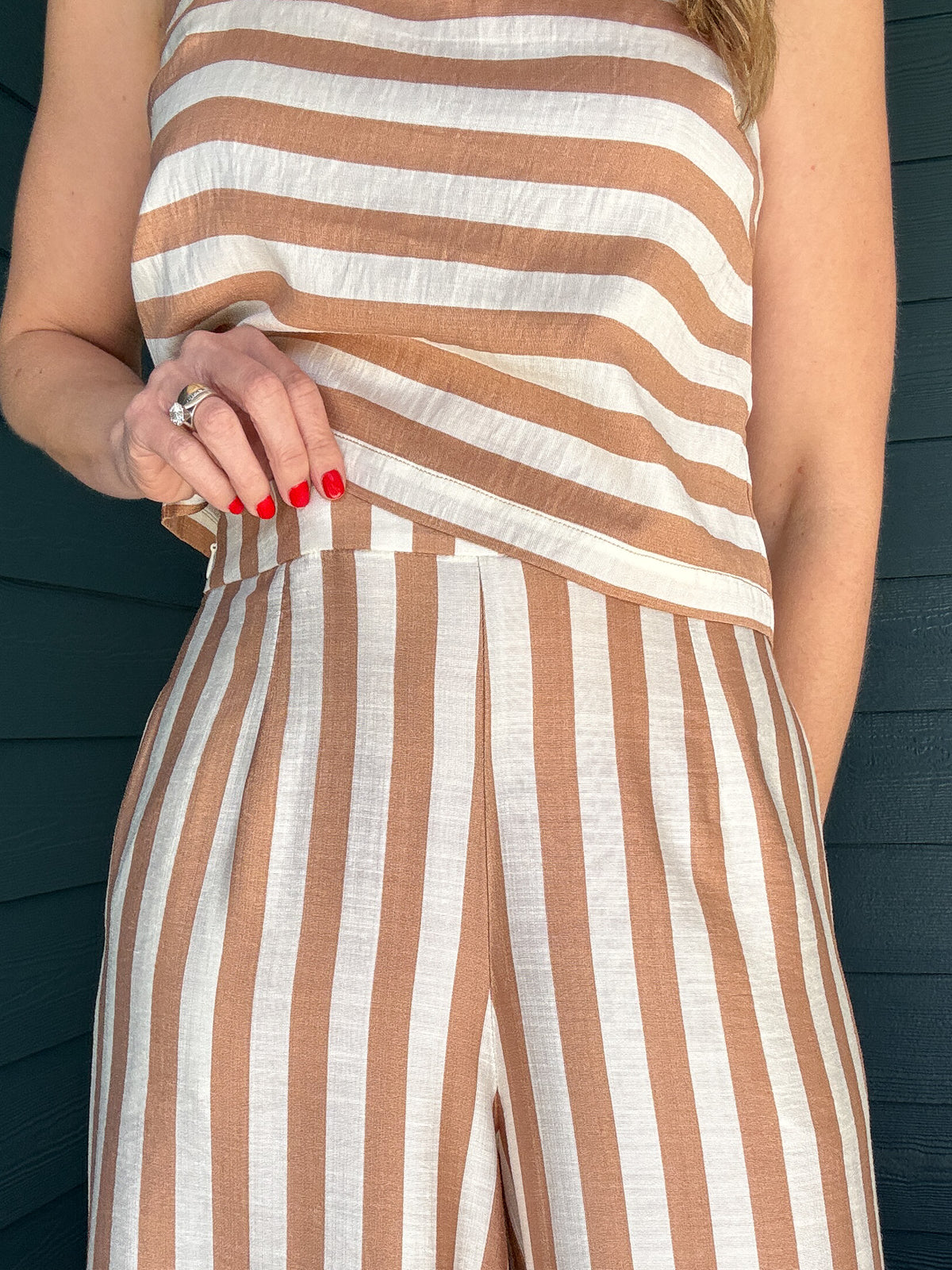 Effortless, breezy, and oh so fun! These full-length billowy pants from Traffic People bring all the flow with their vertical tan and cream stripes, side zipper, flattering flat front waistband, and comfy elastic back. They’ve got pockets (because who doesn’t love pockets?) and a soft lining for easy wear.
They pair with the striped shell top for a playful twist—horizontal stripes, a sleek square neckline, and a slip on design make it the perfect match. A little boho, a little classic, and totally effortle
