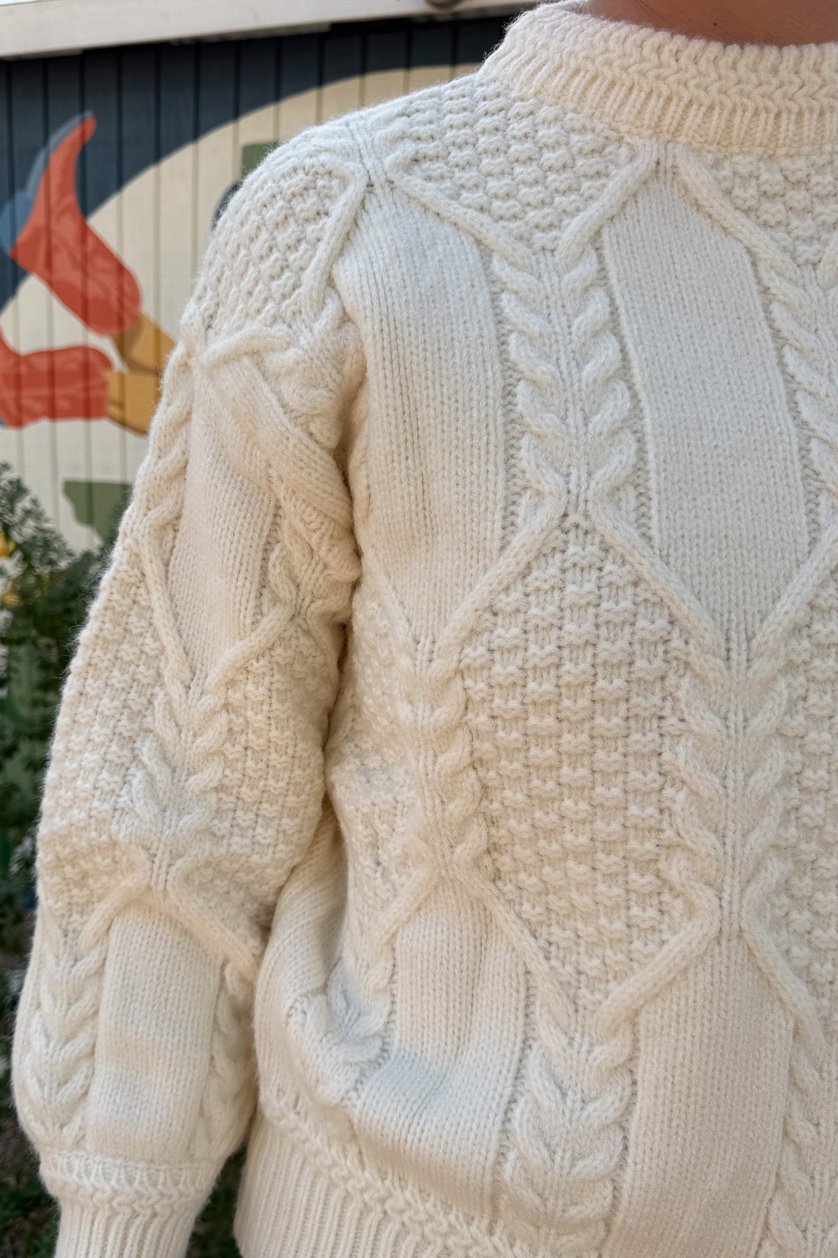 Classic cable knit gets a modern update in this ivory sweater. Designed with intricate knit detailing on the front and sleeves, it features a surprise open-back cutout that adds a chic twist to this timeless style. Soft, cozy, and versatile — it’s the perfect piece for effortless clothing and everyday wear.