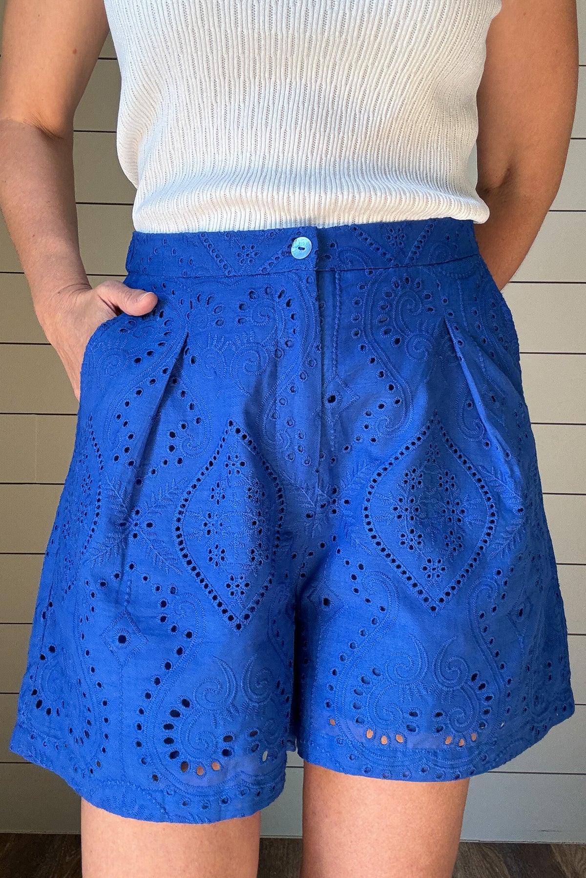 These cobalt blue eyelet shorts are your warm-weather staple with a playful twist. Fully lined for comfort, they offer coverage without bulk. The 4" inseam hits just right for easy movement and everyday wear. A flat front waistband keeps the fit clean, while faux back pockets add a tailored touch without the extra bulk. The waistband is elastic in the back which gives room for movement.