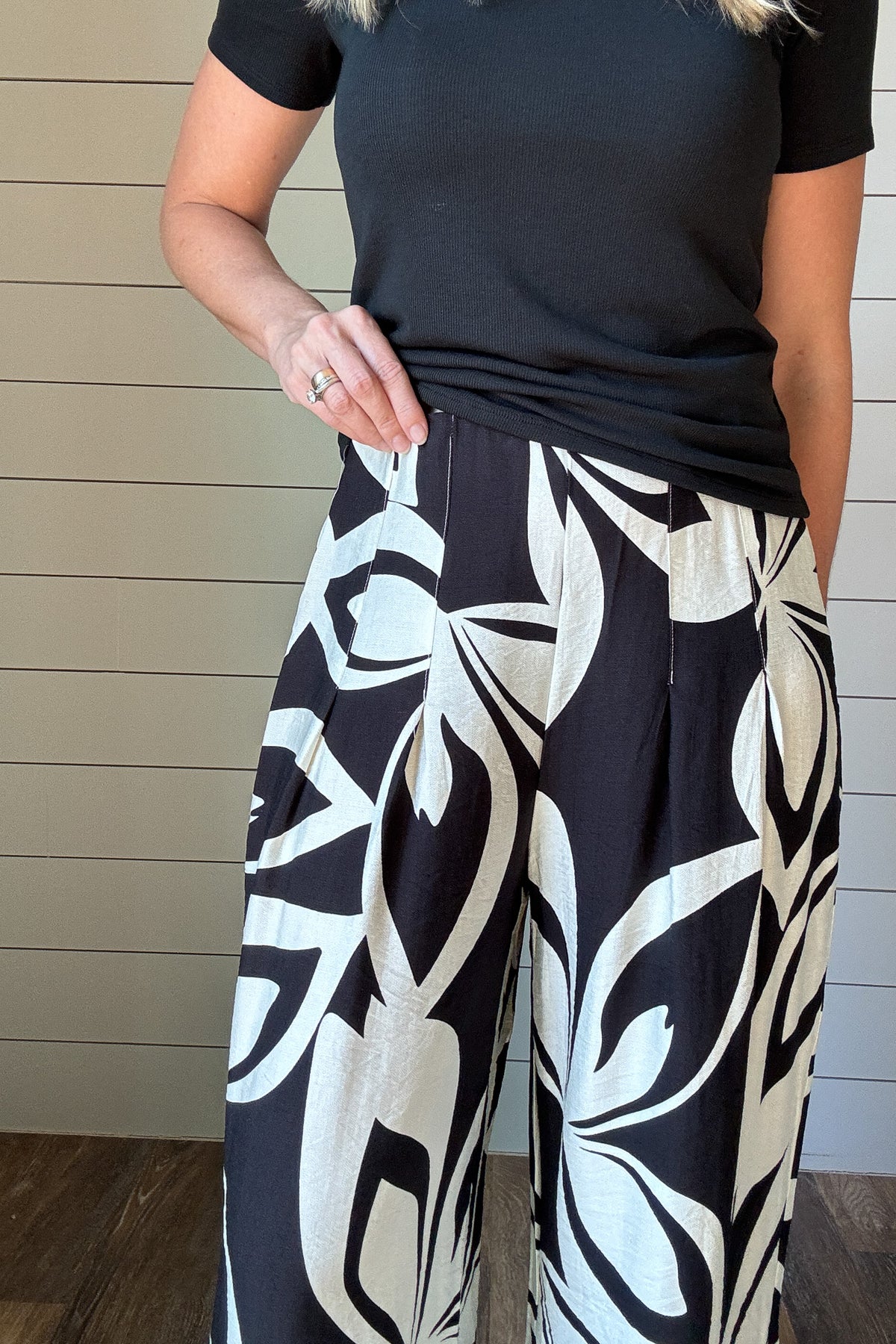 Effortless style meets all-day comfort in these wide-leg pants. Designed with a bold black-and-white abstract print, they’re the perfect statement piece for your everyday wardrobe. The elastic waist keeps the fit comfortable, while front pleats add shape and movement. Pair them with a simple tee or tank for a casual look, or dress them up with a chic blouse for a night out.