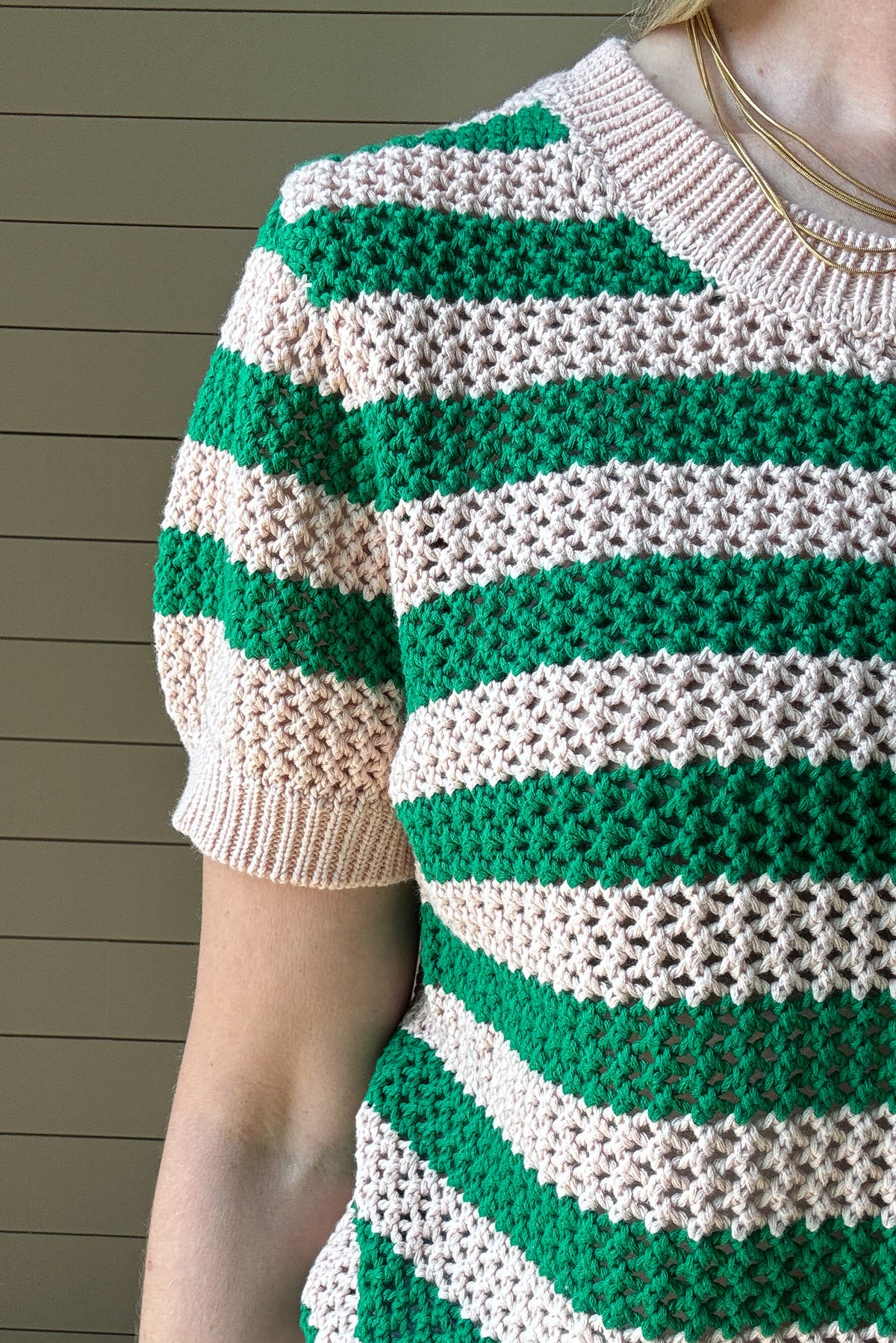 The close knit Green & Blush Short Sleeve Top is the perfect blend of timeless style and everyday comfort. Crafted from 100% cotton, this breathable knit top offers a lightweight feel while maintaining a cozy texture. The intricate open-knit pattern showcases alternating green and blush stripes, creating a fresh and vibrant look.
With its classic crew neckline and ribbed trim on the sleeves and hem, this top provides a flattering and effortless fit. The short sleeves make it an easy transitional piece,