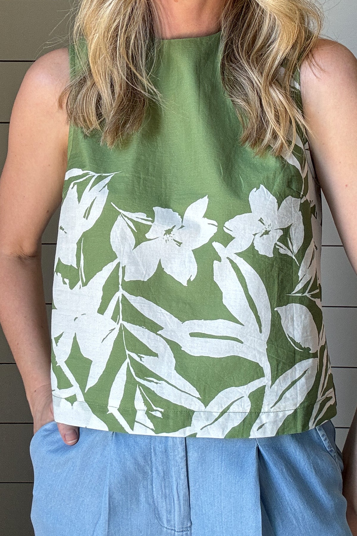 Breezy and effortlessly chic, this sleeveless floral-print top is a perfect blend of structure and ease. With an outer shell that is crafted from100% cotton, it features a fully lined lightweight interior for a polished finish and comfortable wear. The vibrant green base is accented with a bold white floral pattern, bringing a fresh, botanical touch to your wardrobe.