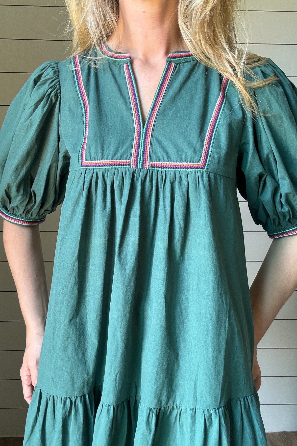 The Meadow Tiered Dress is a breezy, feminine style made for easy days. Crafted from 100% cotton, it’s soft, breathable, and perfect for warmer weather. This knee-length dress features three unlined tiers that create movement and a relaxed shape. The standout details are in the sleeves and neckline—billowed sleeves with a dramatic puff and delicate straight-line embroidery that adds a touch of texture and charm. The same embroidery traces the neckline for a finished, elevated look. Did we mention she has po
