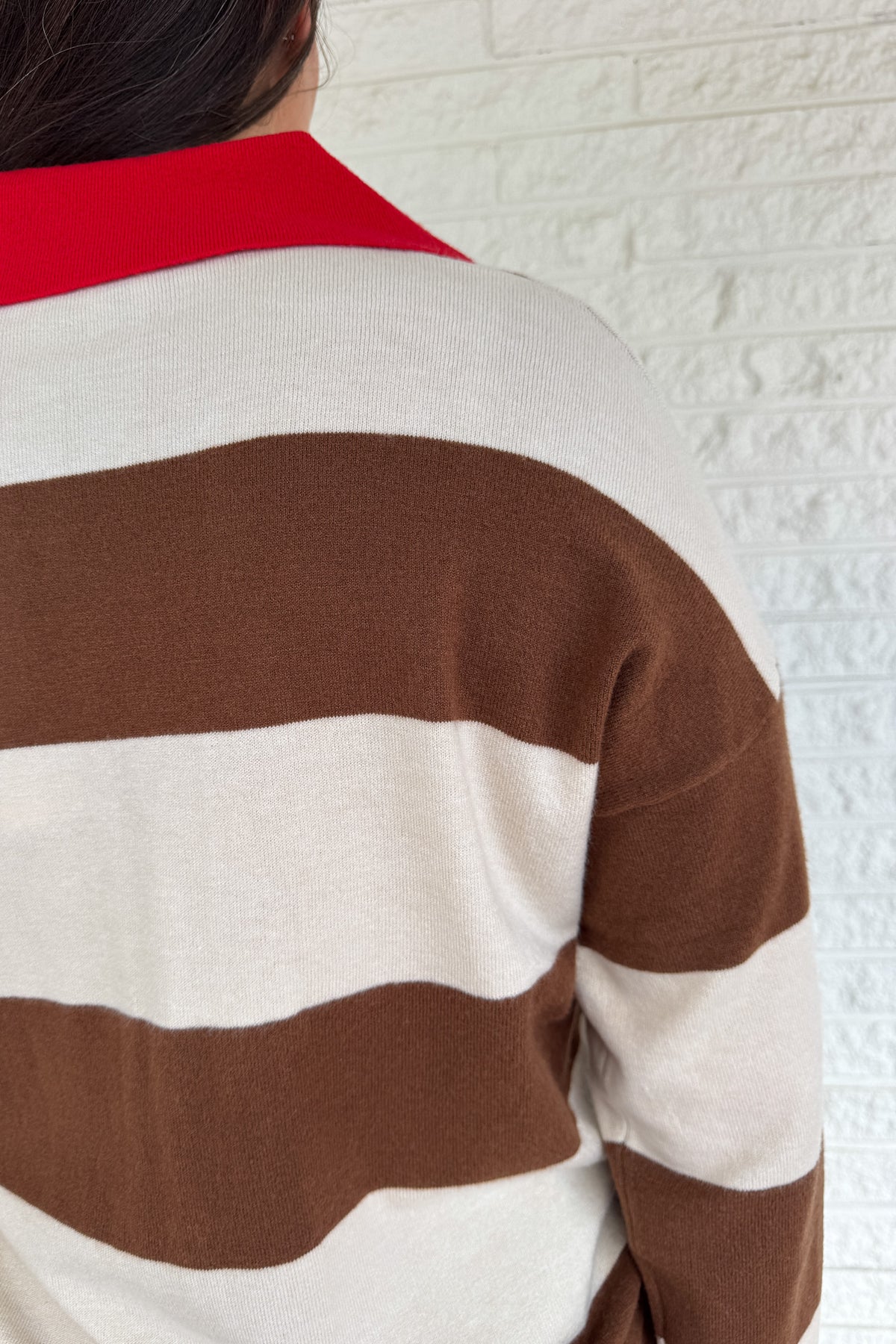  A sporty twist on classic prep, this rugby-style sweater is made for everyday wear with effortless clothing appeal. Featuring bold brown and cream stripes with a pop of red at the collar and neckline, it brings casual comfort with a standout edge. The mid-weight knit feels soft yet structured, perfect for layering or wearing solo.