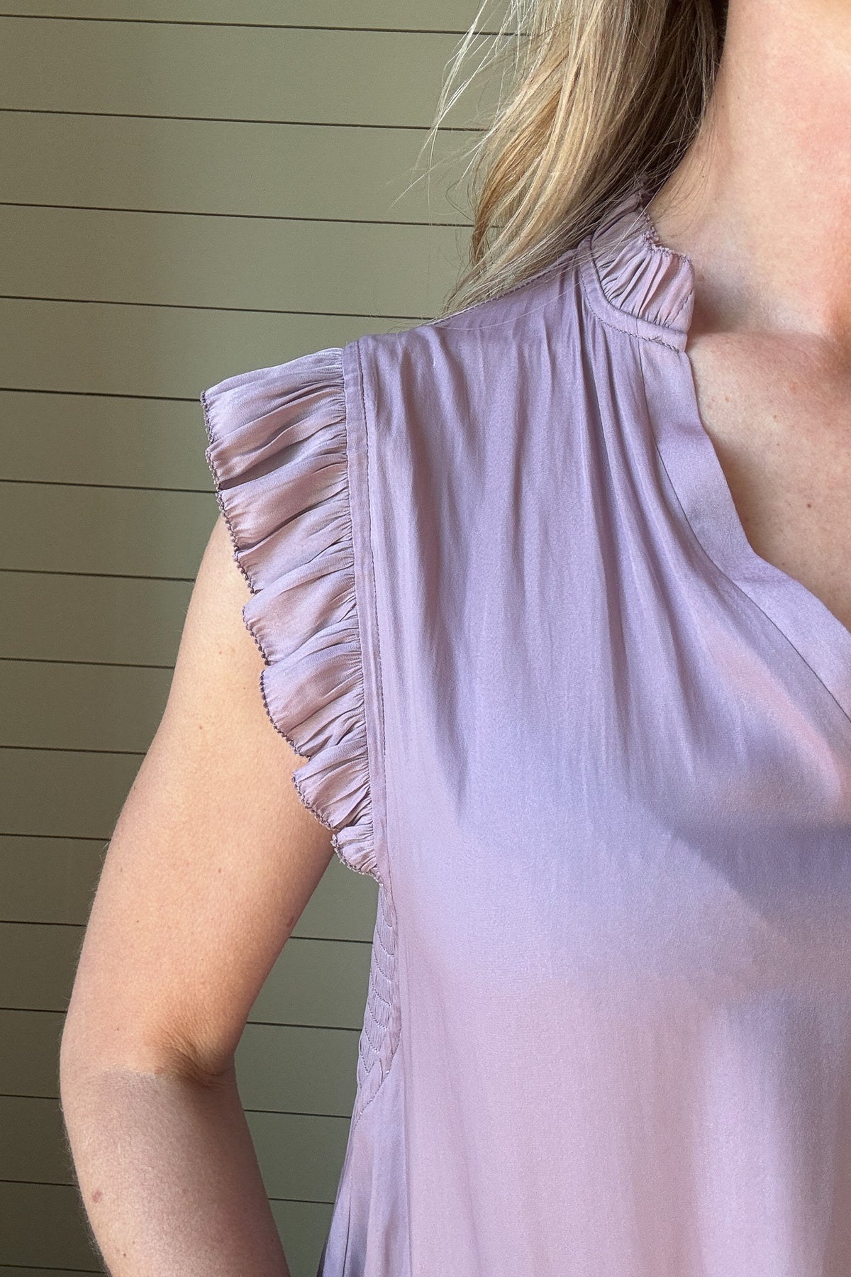 Indulge in luxurious style with our Satin Ruffle Sleeve Blouse. Crafted from lightweight satin fabric, in a warm shade of blushing peach. The v-neck and ruffled shoulders add a touch of sophistication to this sleeveless blouse. Elevate your wardrobe with this exclusive piece.