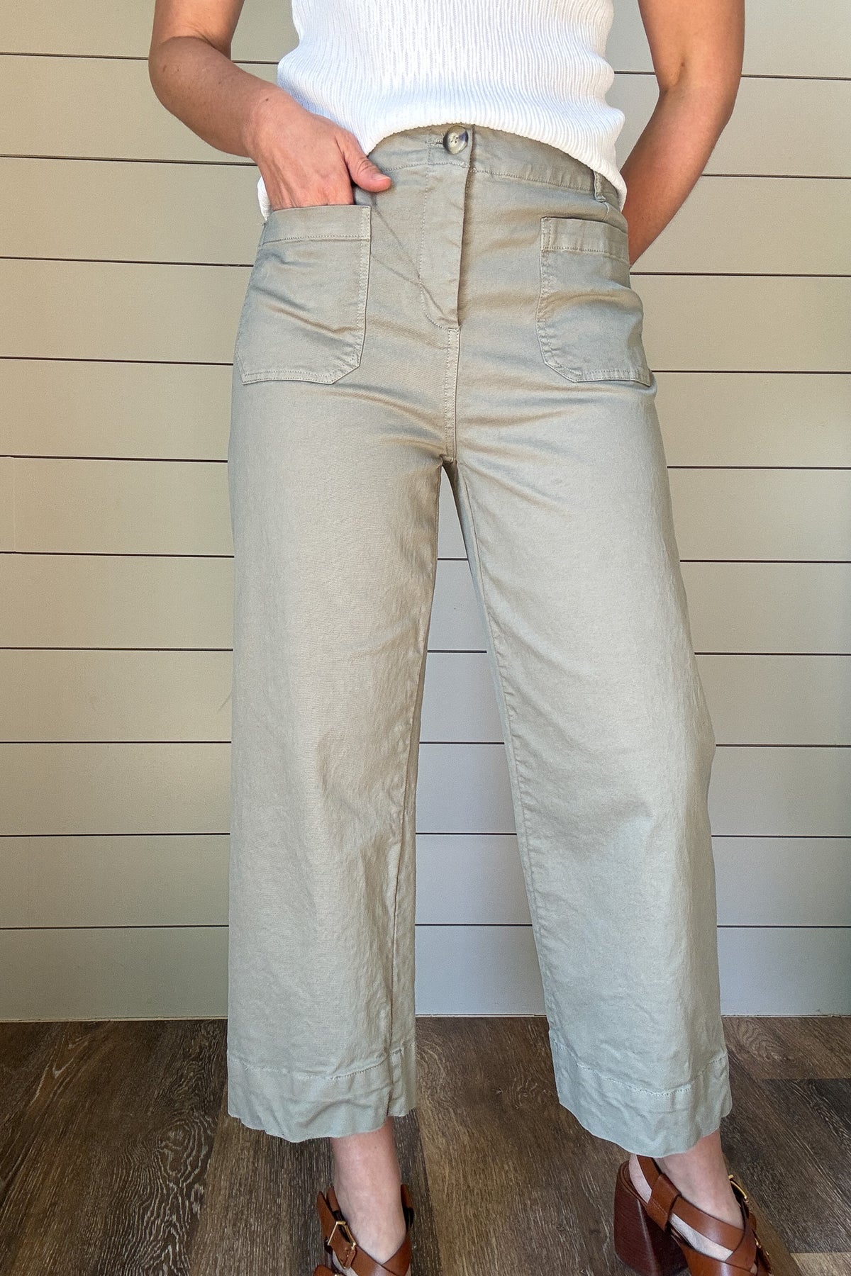 Introducing the luxurious Valeria Pant, a wide leg, cropped chino pant in a soft sage green. With intricate front and back pocket detailing and a button front, this pant exudes sophistication and exclusivity. Elevate your wardrobe and make a statement with this elegant and tasteful piece.