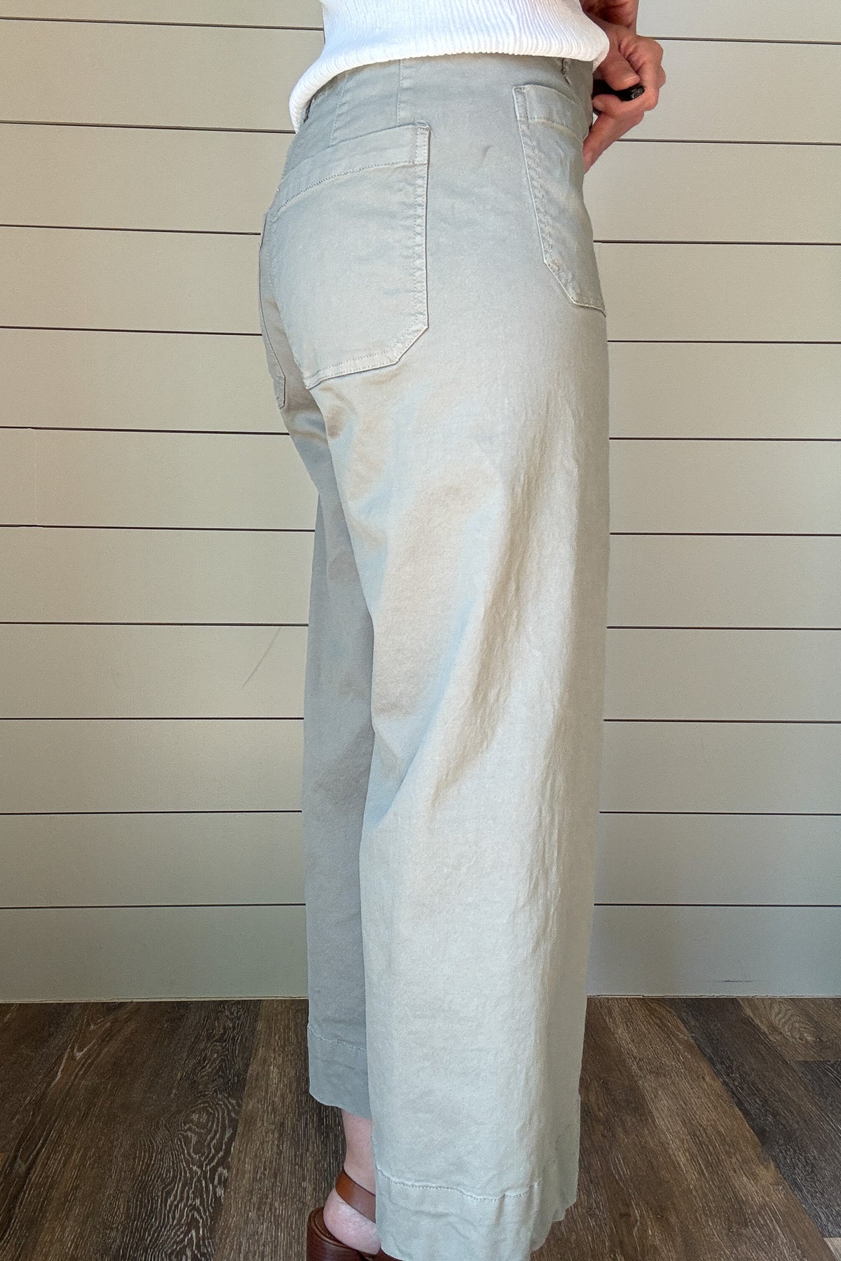 Introducing the luxurious Valeria Pant, a wide leg, cropped chino pant in a soft sage green. With intricate front and back pocket detailing and a button front, this pant exudes sophistication and exclusivity. Elevate your wardrobe and make a statement with this elegant and tasteful piece.