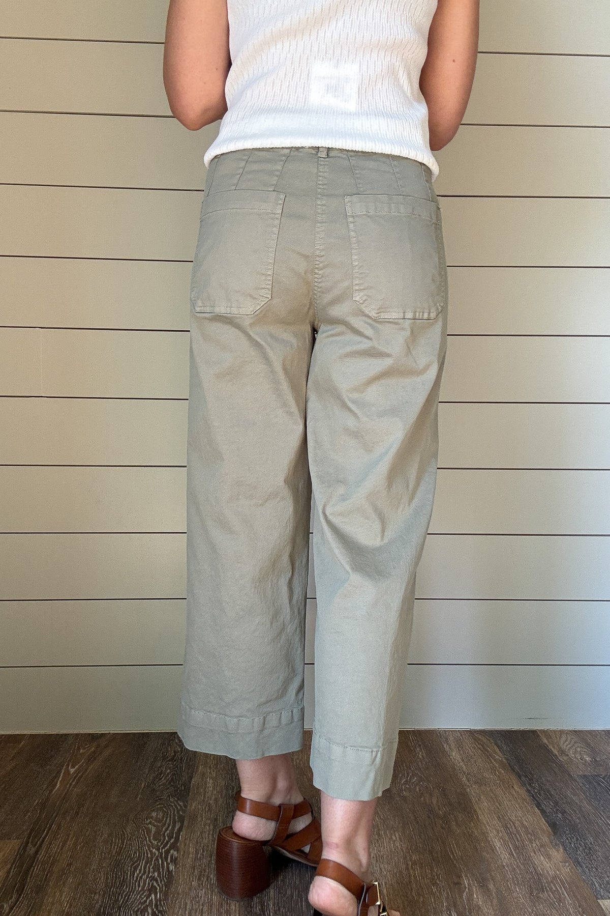 Introducing the luxurious Valeria Pant, a wide leg, cropped chino pant in a soft sage green. With intricate front and back pocket detailing and a button front, this pant exudes sophistication and exclusivity. Elevate your wardrobe and make a statement with this elegant and tasteful piece.