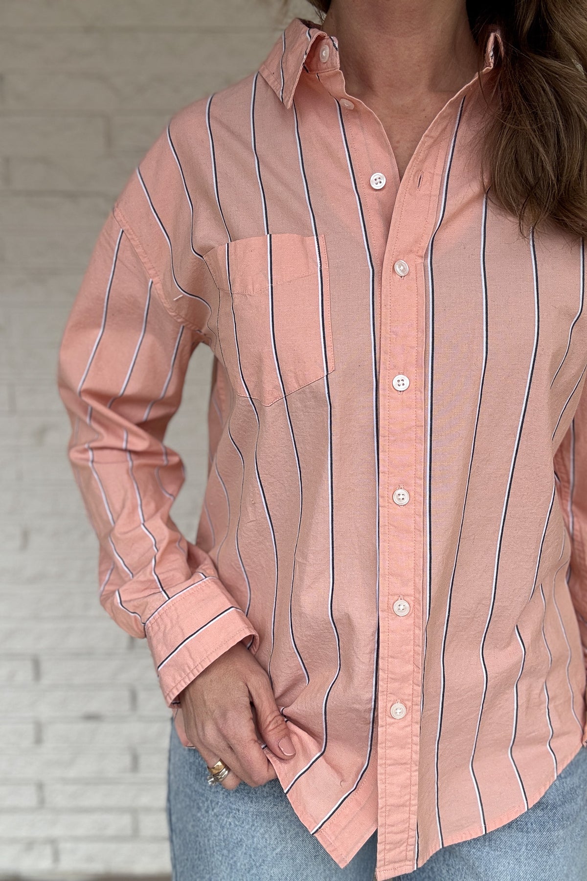 This striped button-down is an easy, everyday staple you’ll reach for on repeat. Made from breathable 100% cotton, it has a relaxed feel with a polished look that works tucked, tied, or worn open over a tee. The peach tone and vertical stripe keep it flattering and effortless from workdays to weekends.

Key Features