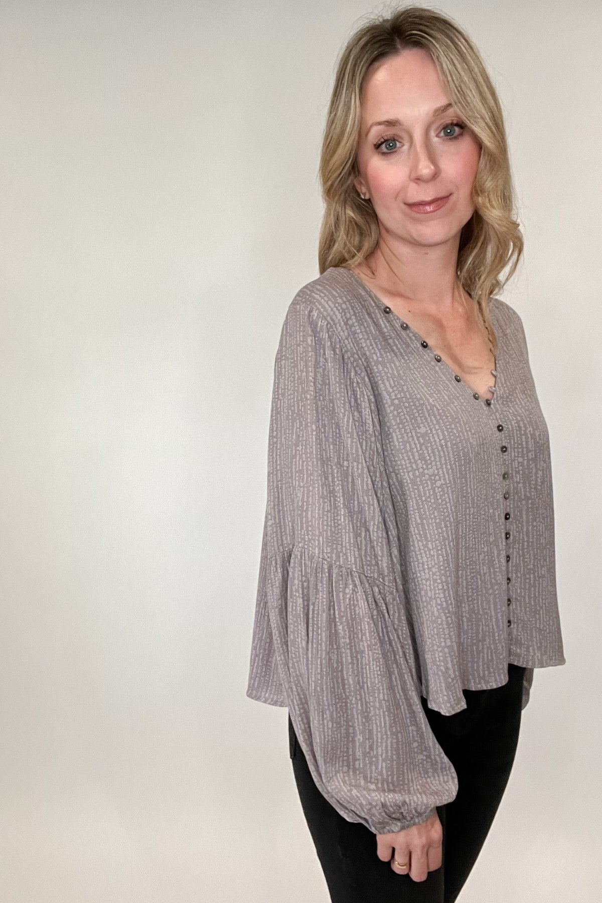 Stunning and sophisticated, you simply cannot go wrong with our Buttons Blouse. With a lined, v-neck design and lavish gray and lavender undertones and a patterned print, this blouse will have you dressed for your day in no time. Its faux button front ensures a secure, yet comfortable fit with no gapping, while buttons and button hooks run along the neckline for an extra touch of style. A truly luxurious essential that looks and feels perfect.