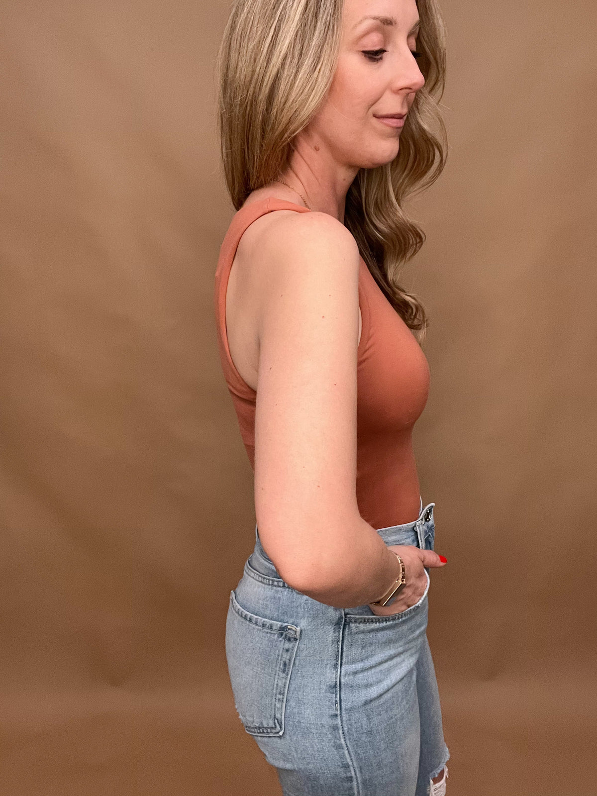 This sleek Round Neck, Sleeveless Knit Bodysuit is crafted with the highest quality materials and proudly made in America. Its warm copper tone brings a luxurious look and feel, ensuring that it will become a timeless staple in your wardrobe.
