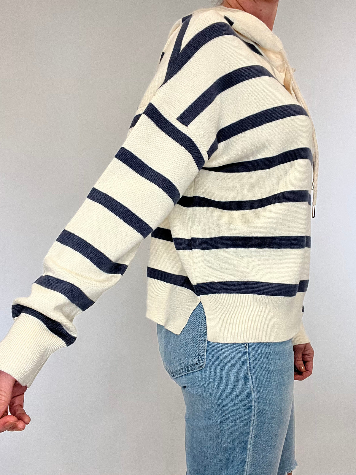 Sail away in style with The Nautical Hoodie. This luxurious heavy-weight, fine knit sweater features elegant nautical stripes in navy and ecru, exuding effortless chic. Leave the sweatshirt behind and elevate your wardrobe with this gorgeous piece.