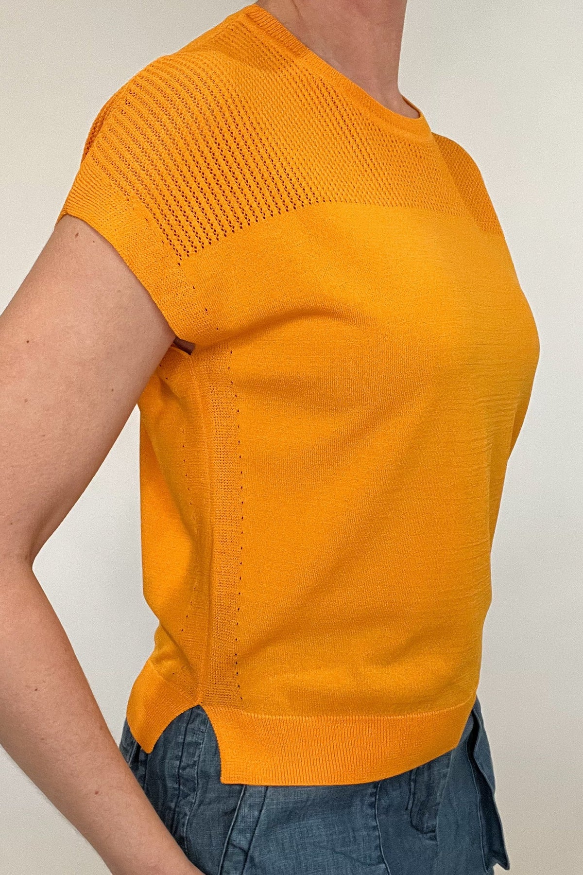 Elevate your spring style with our Laser Cut Summer Sweater. The open weave design over the shoulders and upper chest adds a touch of lightness to this vibrant and chic piece. With color options in grass green and bright orange, pair it effortlessly with chambray pants or white denim for a stylish look.