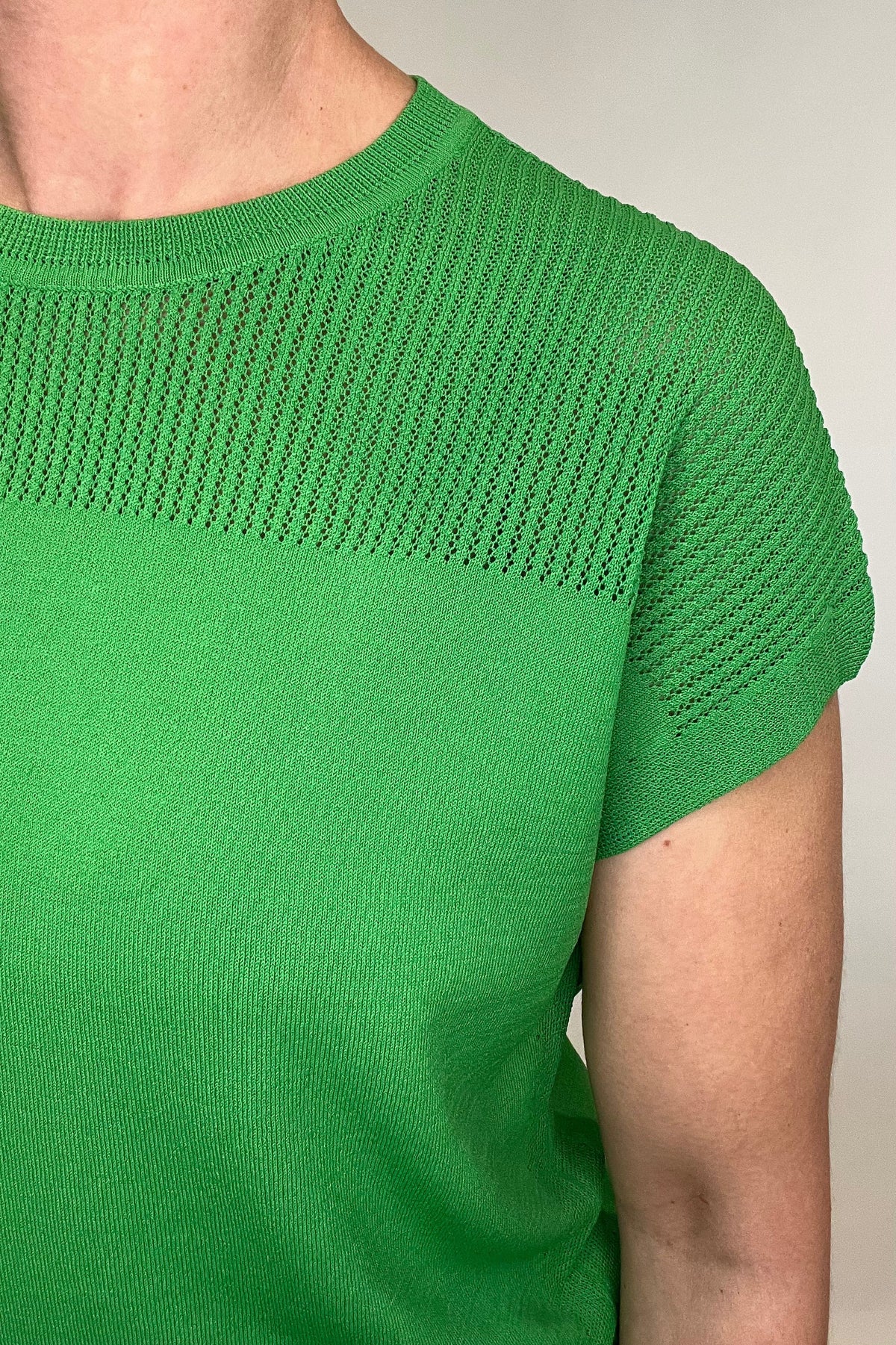 Elevate your spring style with our Laser Cut Summer Sweater. The open weave design over the shoulders and upper chest adds a touch of lightness to this vibrant and chic piece. With color options in grass green and bright orange, pair it effortlessly with chambray pants or white denim for a stylish look.