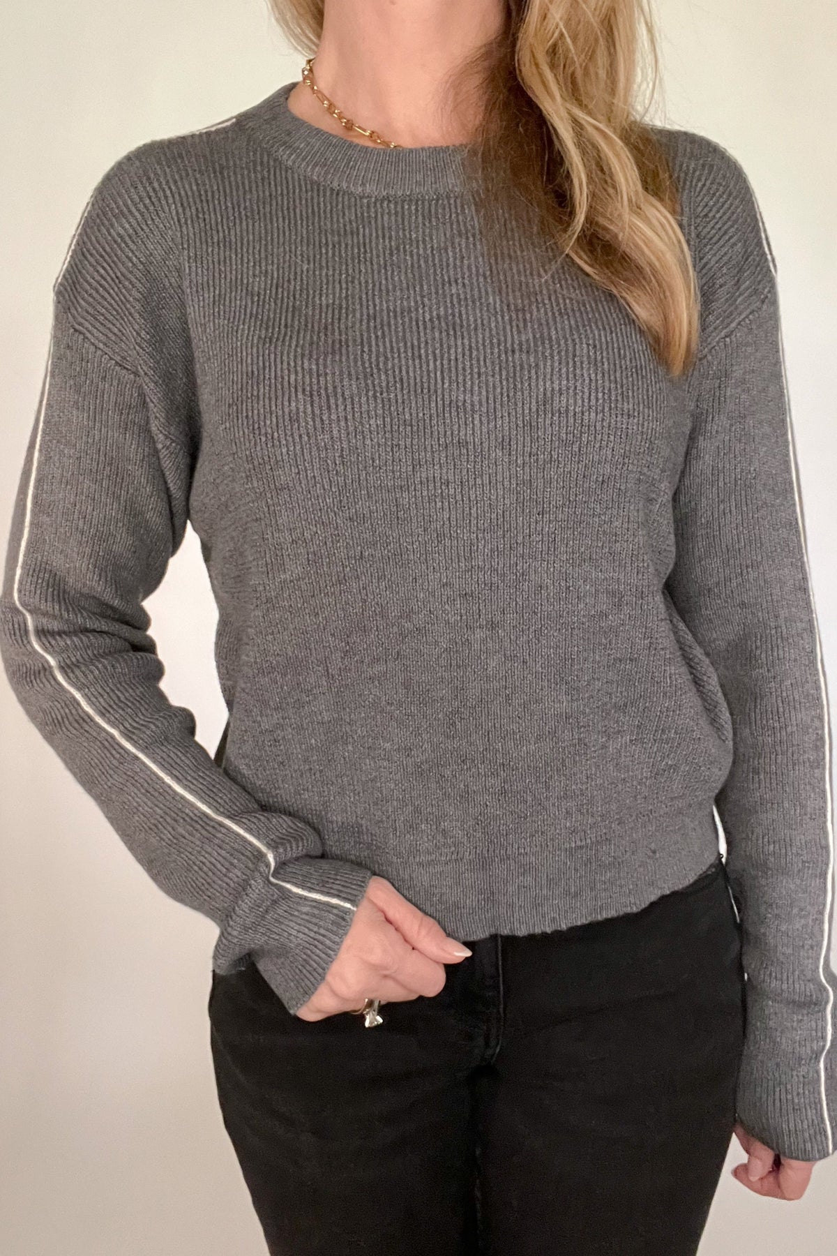 Stylish and timeless, this charcoal stripe sweater is crafted from lightweight yet soft fabric, making it cozy and comfortable. An elegant white stripe running down each sleeve creates a classic, fashion-forward look that pairs perfectly with black jeans. Wear it with confidence and look your best.