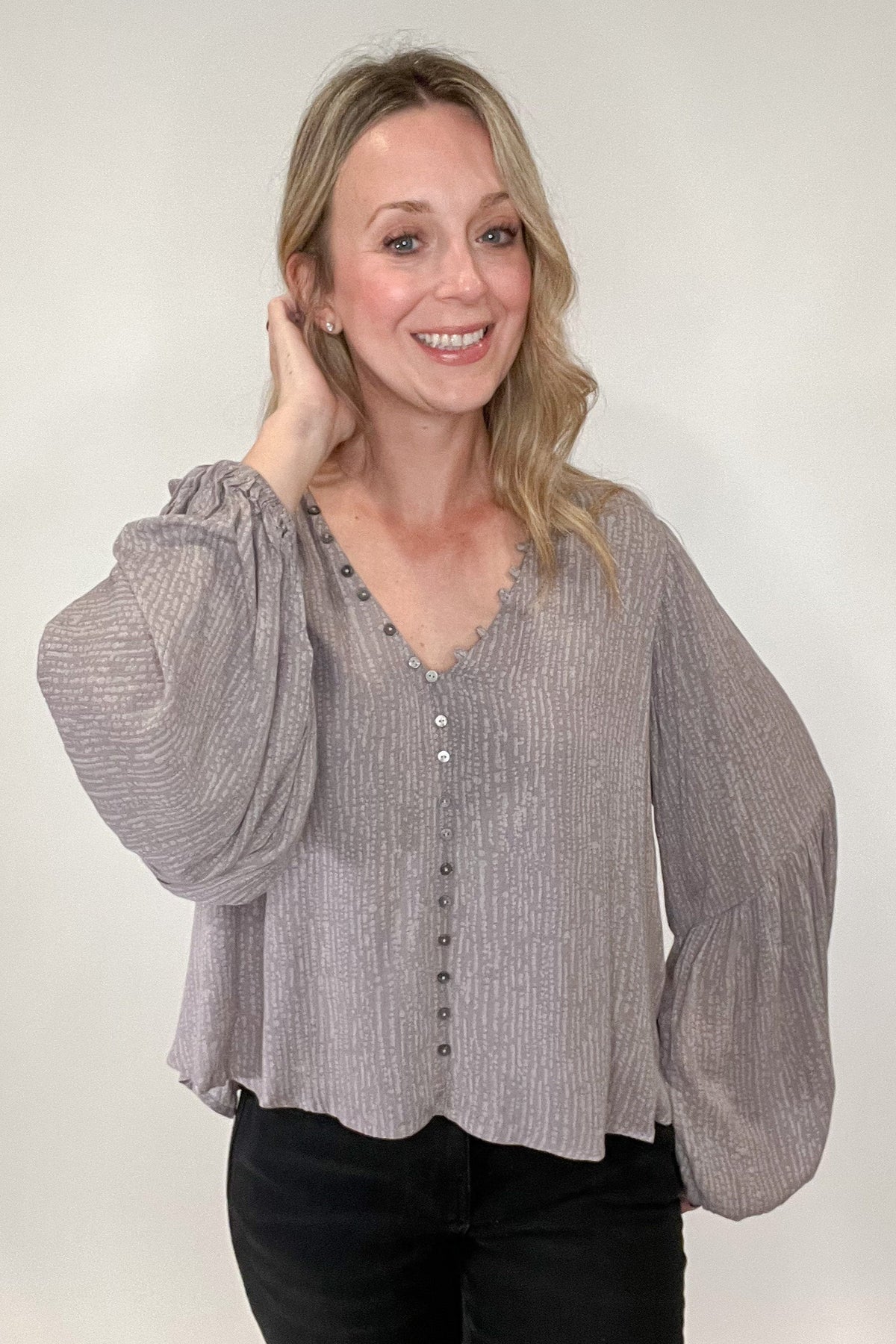 Stunning and sophisticated, you simply cannot go wrong with our Buttons Blouse. With a lined, v-neck design and lavish gray and lavender undertones and a patterned print, this blouse will have you dressed for your day in no time. Its faux button front ensures a secure, yet comfortable fit with no gapping, while buttons and button hooks run along the neckline for an extra touch of style. A truly luxurious essential that looks and feels perfect.