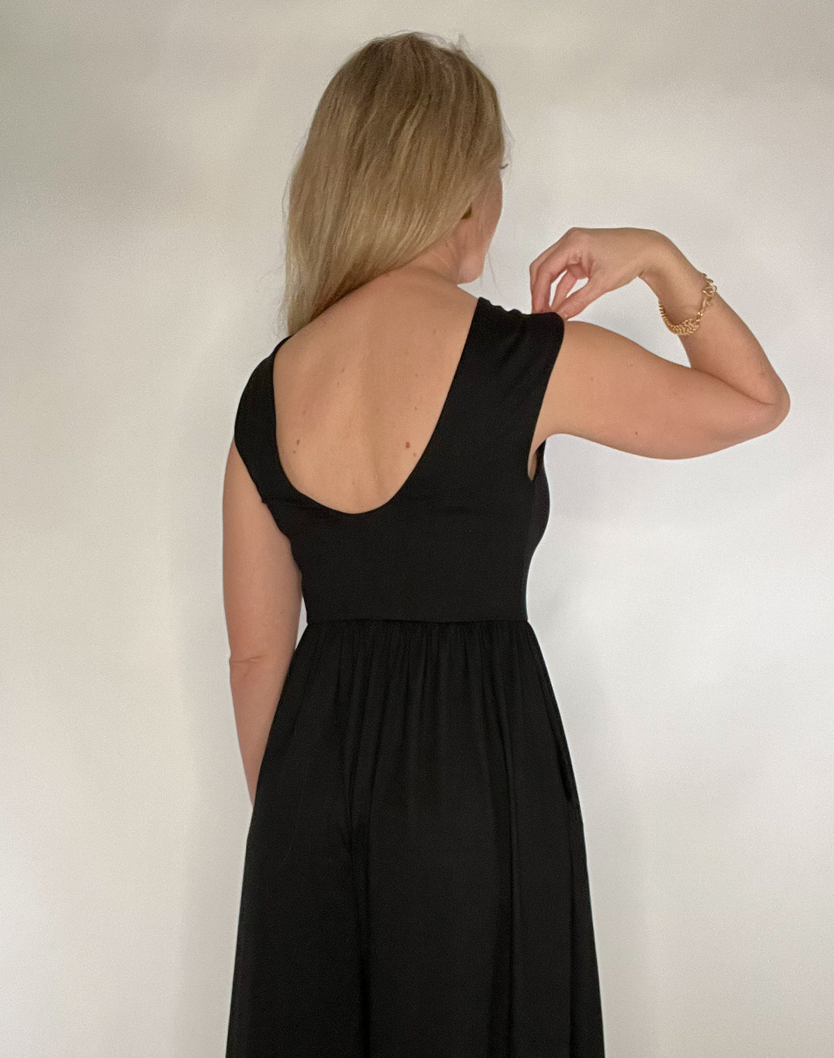 The Illusive Jumper is a versatile and comfortable piece that combines the elegance of a dress with the convenience of a romper. Made with luxurious black jersey fabric, it features angled hem, pockets, and a low cut back with wide straps for bra support. The fitted bodice flares at the waist for a flattering silhouette. Elevate your style with this sophisticated and artful piece.