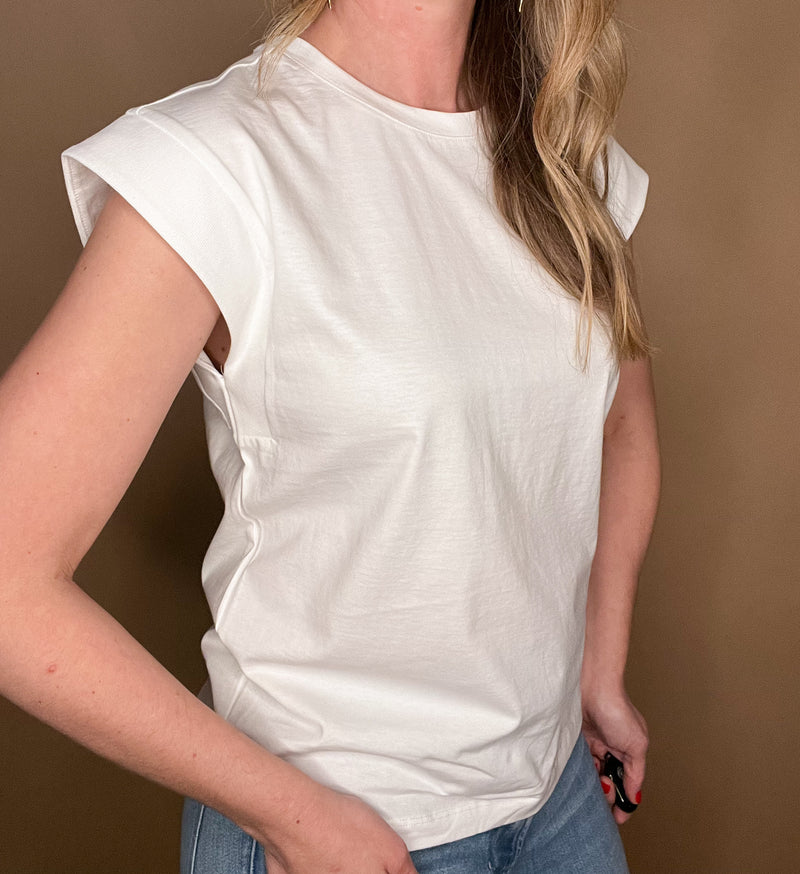 Elevate your wardrobe with our White Shoulder Detail Tee! This closet staple is made from 100% cotton, offering both comfort and style. The shoulder detailing adds a unique touch to this classic white tee. Perfect for layering or pairing with denim cut offs for a timeless warm weather look.