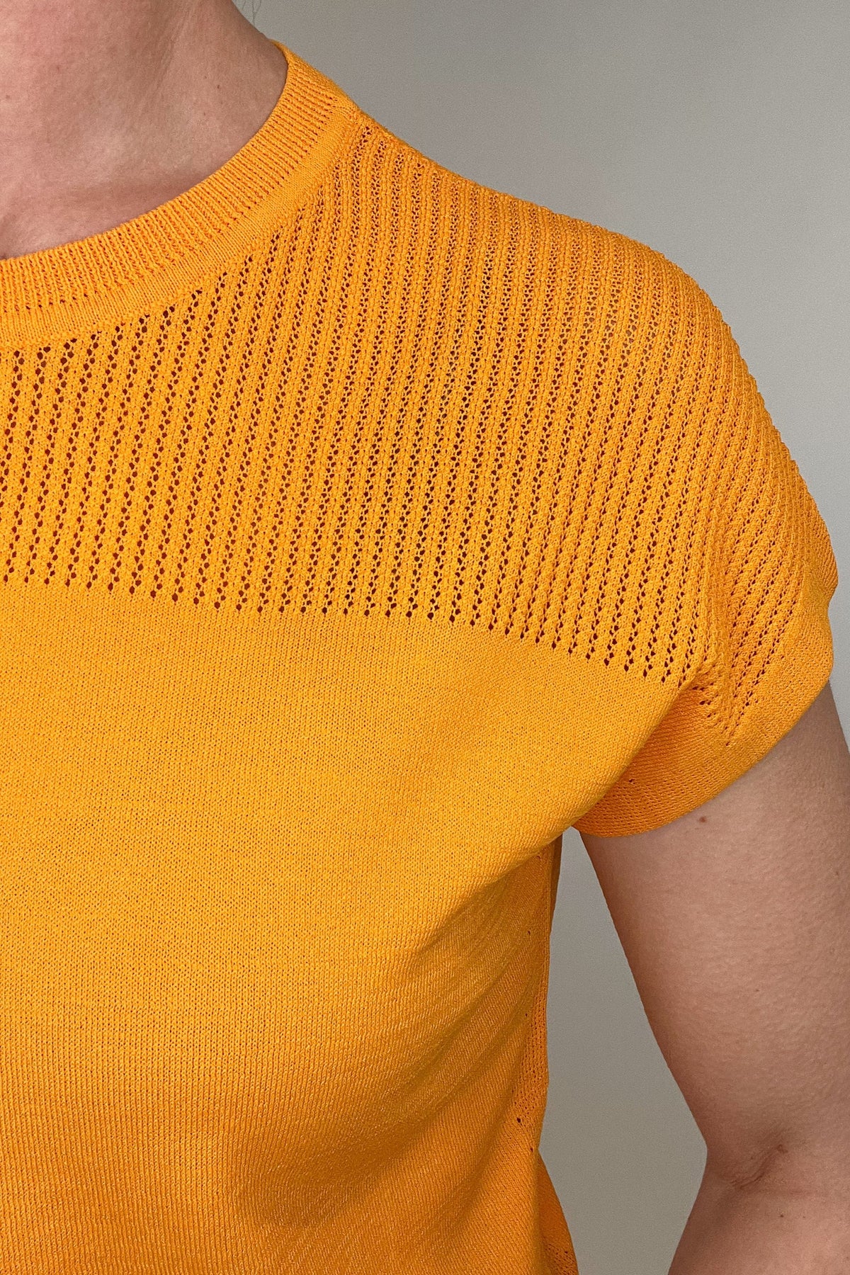 Elevate your spring style with our Laser Cut Summer Sweater. The open weave design over the shoulders and upper chest adds a touch of lightness to this vibrant and chic piece. With color options in grass green and bright orange, pair it effortlessly with chambray pants or white denim for a stylish look.