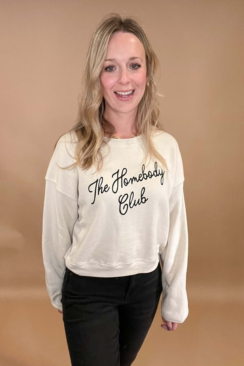 This Homebody Club Sweatshirt is a luxurious statement piece for those cozy days at home. Crafted from cozy cream fabric and black print, this sweatshirt is perfect for you or for a special someone. Wearing it will remind you that it's always homebody season.