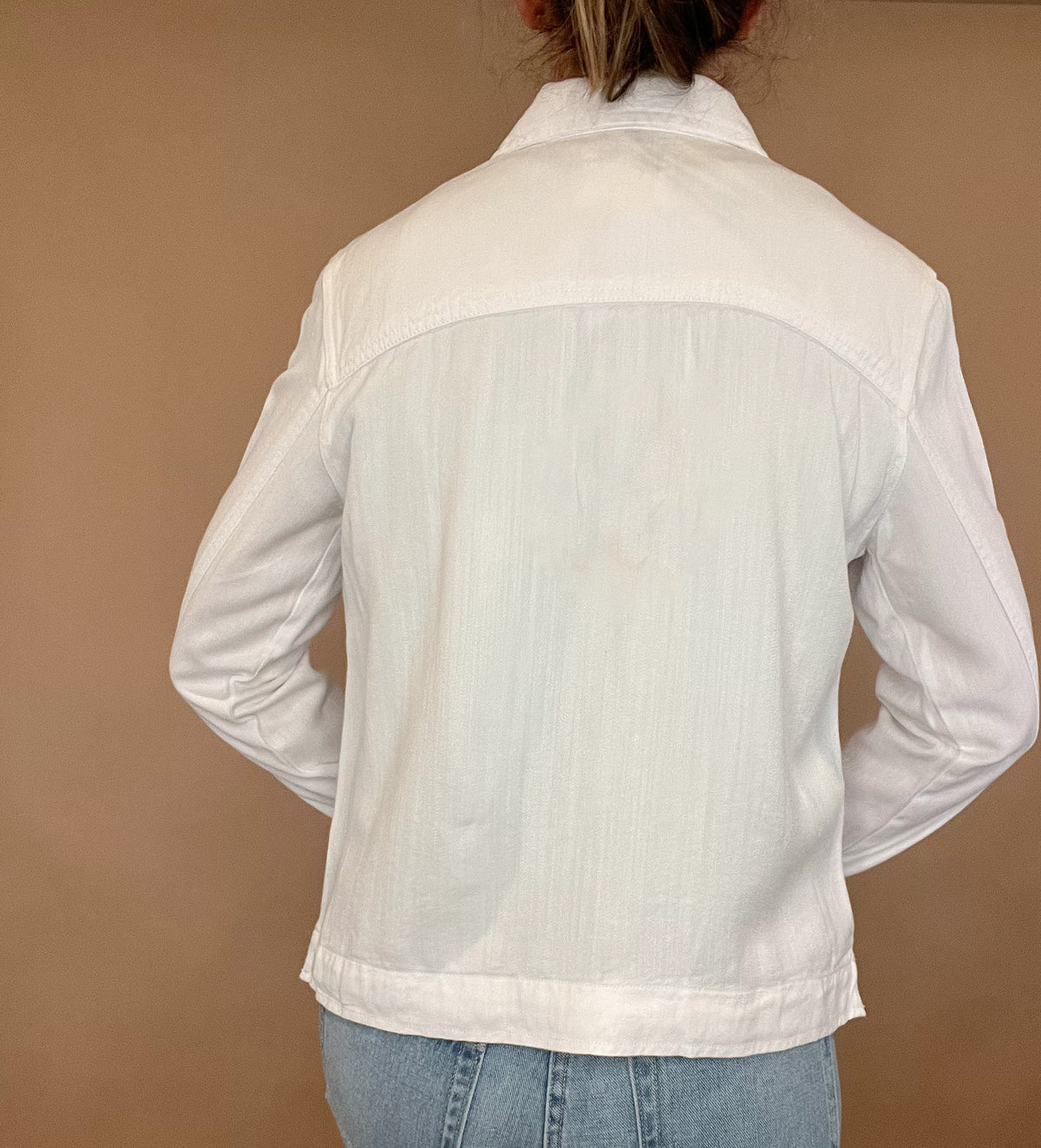 The "perfect" top layer for chic and casual looks, this white denim jacket is a must-have. With a stretchy fit that stays true to size, it features double chest pockets for practicality and style. Upgrade your wardrobe with this versatile jacket.