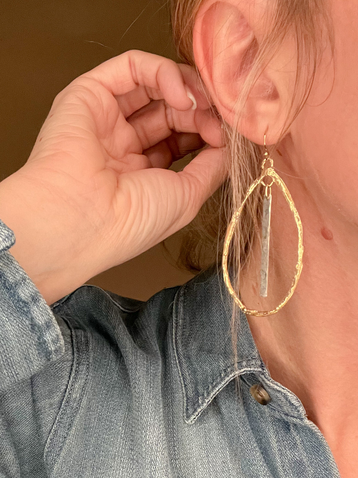 Indulge in the exquisite artistry of these teardrop hoops, handcrafted with hammered Gold Bronze and Sterling Silver accents on Gold filled ear wires. Measuring a regal 2 3/4-inches, these earrings emanate elegance and are proudly made in the USA.