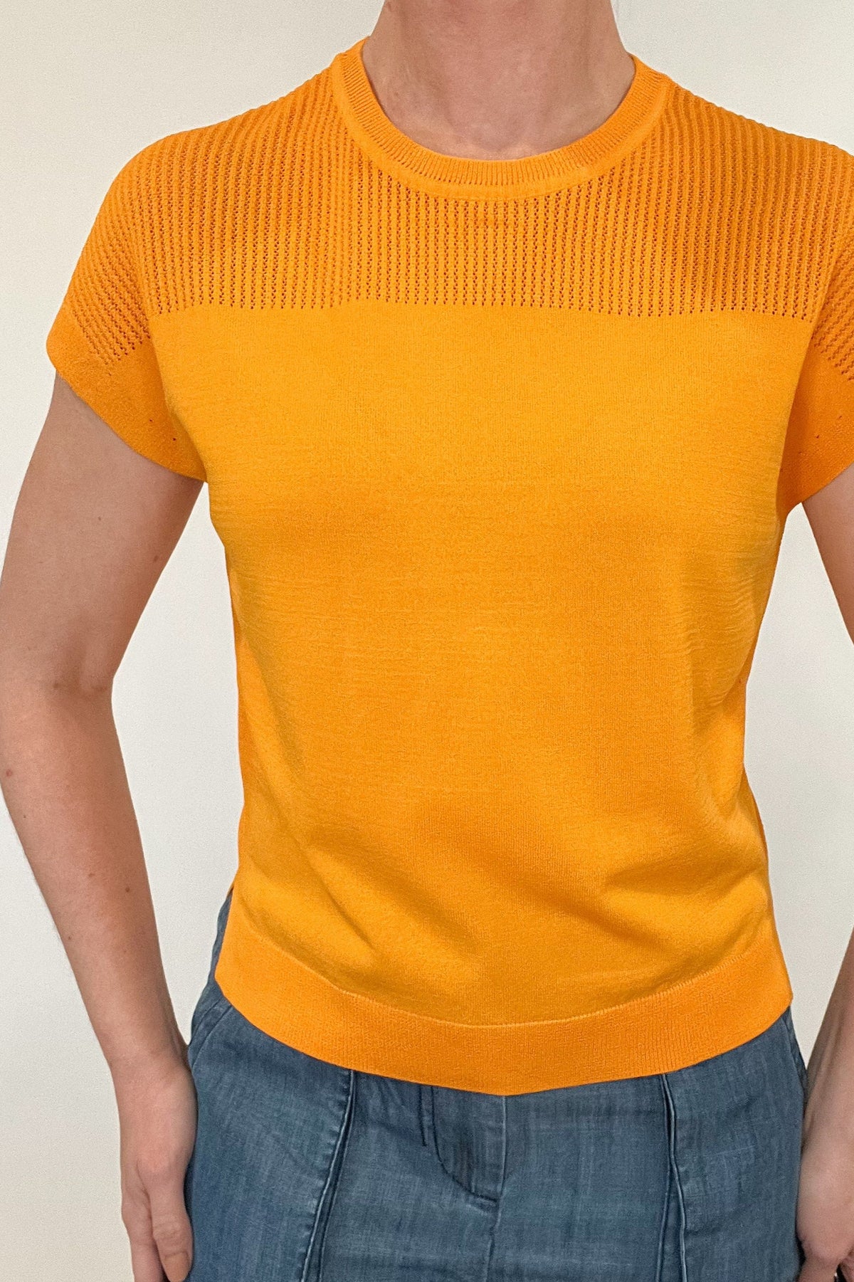 Elevate your spring style with our Laser Cut Summer Sweater. The open weave design over the shoulders and upper chest adds a touch of lightness to this vibrant and chic piece. With color options in grass green and bright orange, pair it effortlessly with chambray pants or white denim for a stylish look.