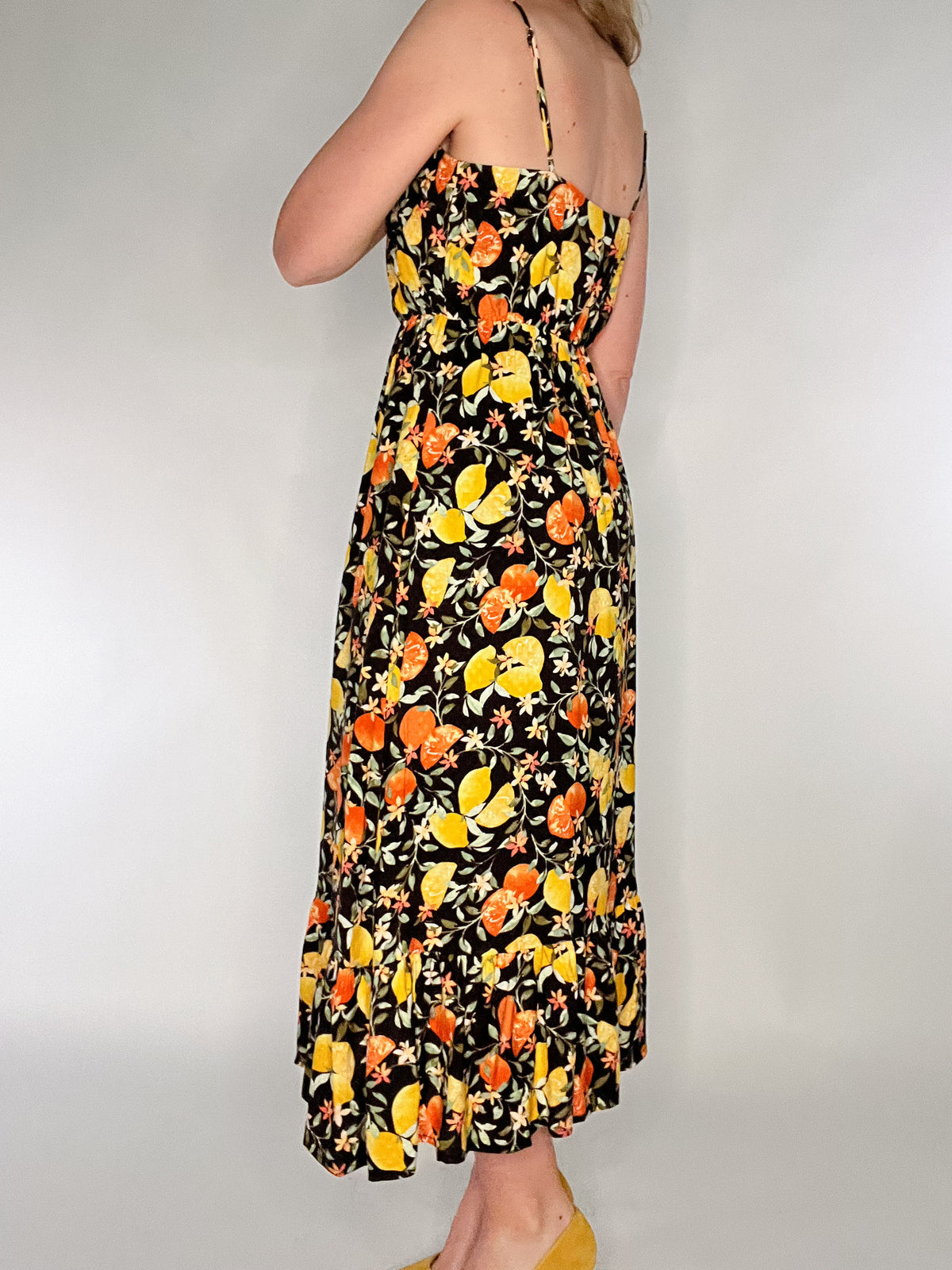 Make a bold statement in our Citrus Punch Maxi Dress. Featuring a playful citrus print, this adjustable spaghetti strap dress is perfect for any occasion. The tiered skirt adds a feminine touch while the button front and elastic waist provide a flattering fit. Fully lined to the knees for ultimate comfort and style.