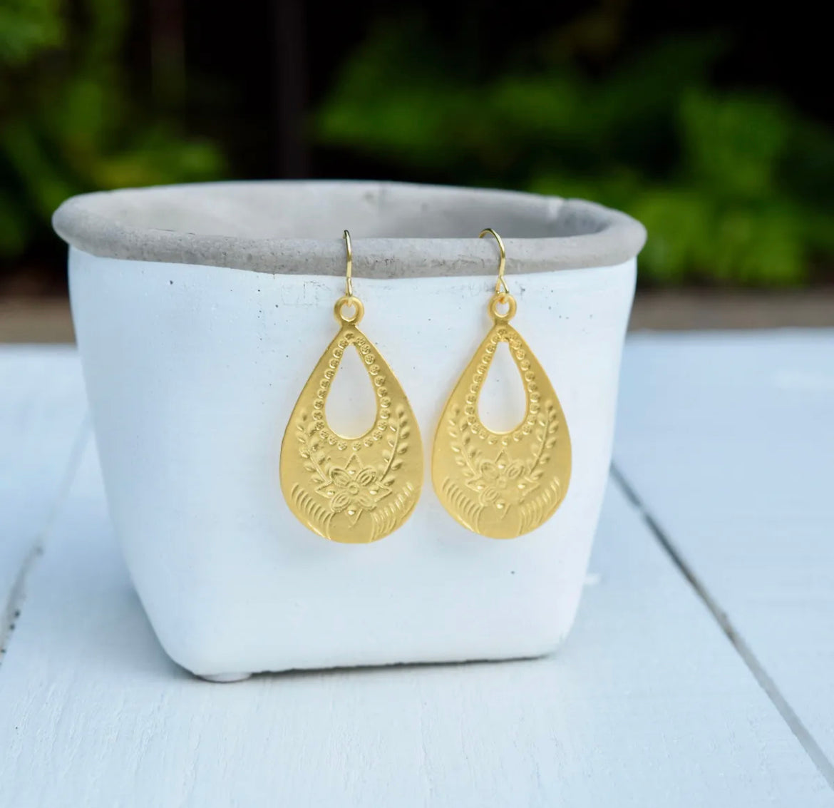 <p><span>Matte gold vintaged styled flower stamped teardrop hoop earrings on 10k gold plated ear wires. They hang approximately 2 1/8 inches. </span></p> <p>Hand made in the USA</p>