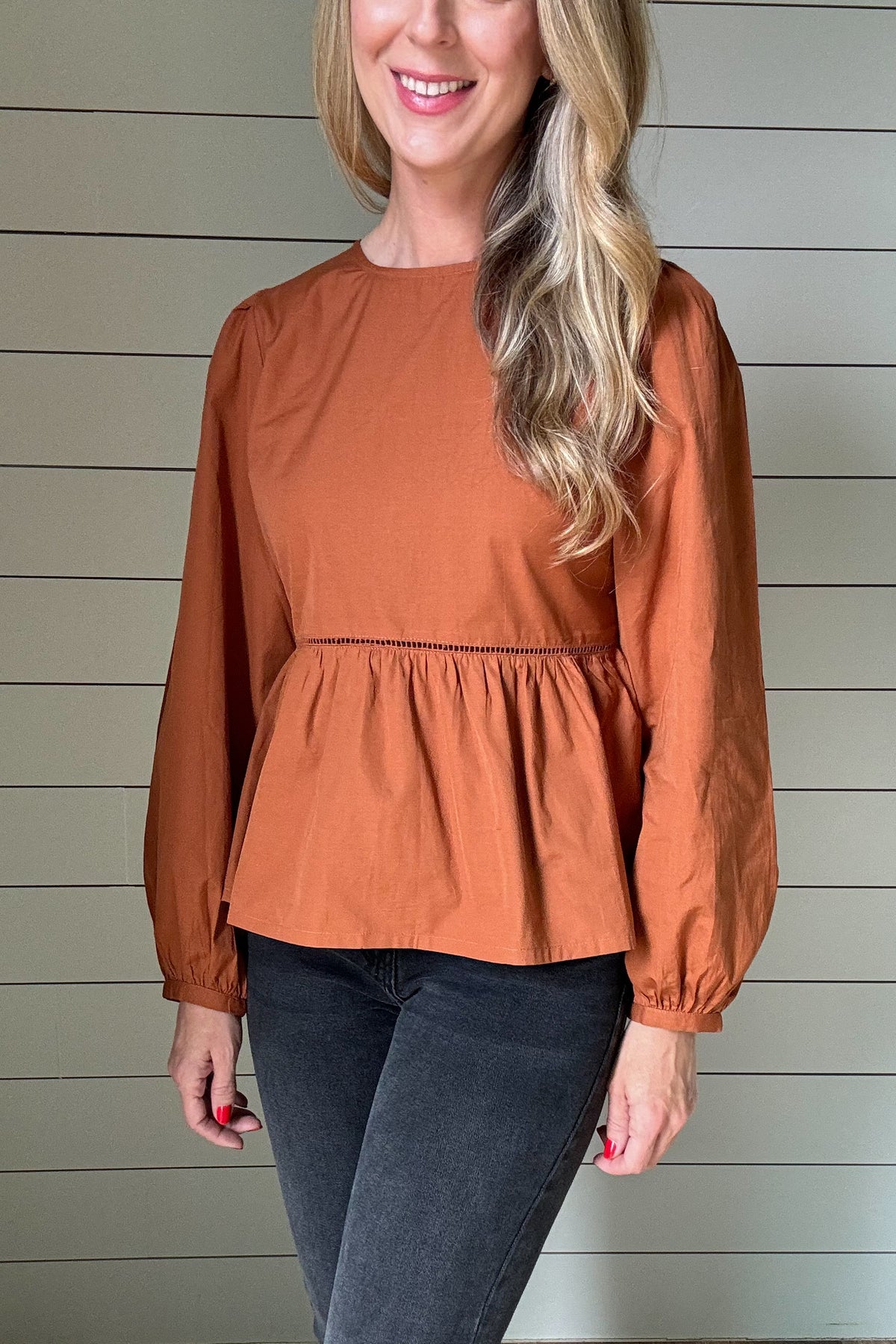 Our Lauren Babydoll Top is perfect for dressing up any look. It features a fitted bodice that flares out below the waist, accented with ladder lace trim at the waist seam. Made from soft poplin with an easy to slip on button back, it offers just enough structure to hold its shape, and it includes a slight puff sleeve for added charm.