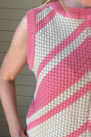 This bold basketweave knit tank is a standout piece with texture and color that pops. Made from 100% cotton, it’s soft, breathable, and perfect for warmer days. The sleeveless cut and crew neckline give it a classic shape, while the pink and cream chevron pattern adds just the right amount of fun. The basketweave knit adds structure without being heavy, making it an easy pick for everyday wear.