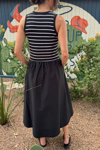 Back view of a women’s black midi dress with a striped ribbed tank bodice, fitted waist and gathered full-length skirt.