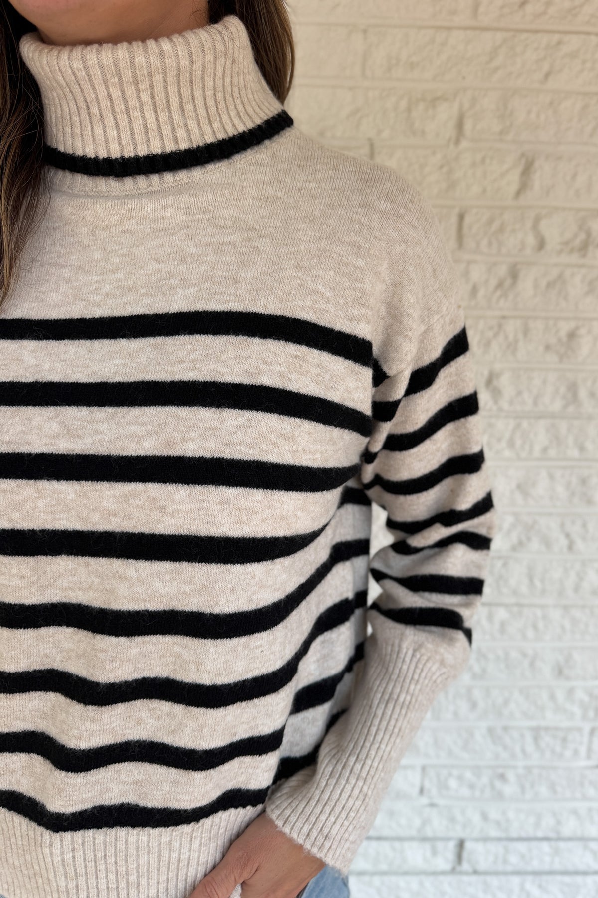 A modern take on the classic striped sweater, this cozy turtleneck features a chic open-back detail for an unexpected twist. Soft and warm with a relaxed fit, it’s an easy statement piece that pairs perfectly with denim or trousers for effortless style.
