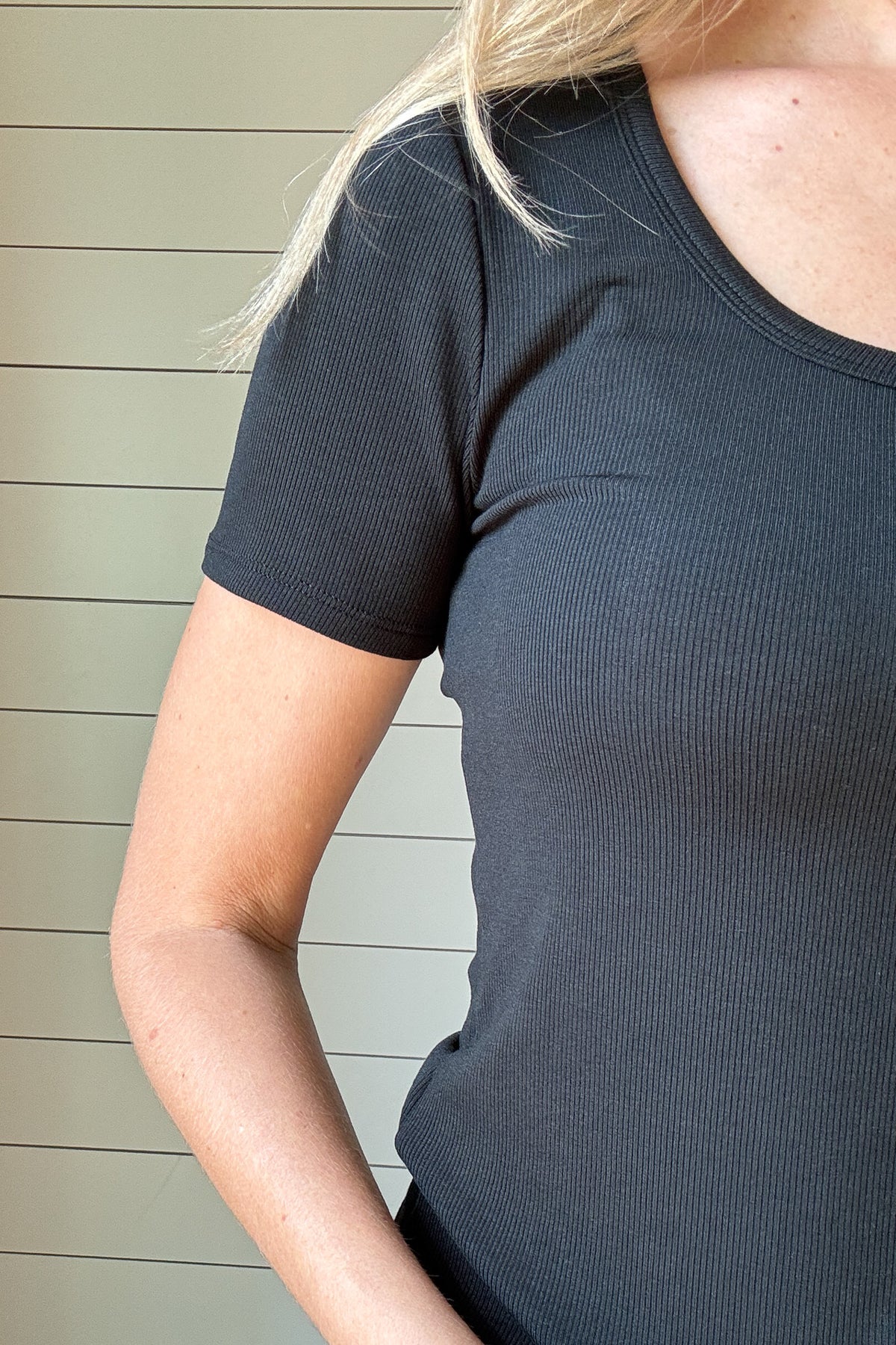 &nbsp;Your perfect layering tee is here. This stretchy black top features a flattering scoop neckline and a soft ribbed texture that hugs without feeling tight. Its short sleeves and slim fit make it easy to wear on its own or under your favorite jacket or cardigan. A timeless staple you’ll want in every color.