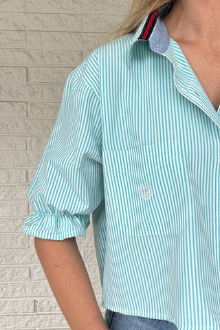 Front photo:
VonVie Harlow aqua and white striped cropped button down shirt with chest pocket, puff sleeves, and ruffled cuffs

Back photo:
Back view of VonVie Harlow aqua striped shirt with open back and red and navy ribbon ties