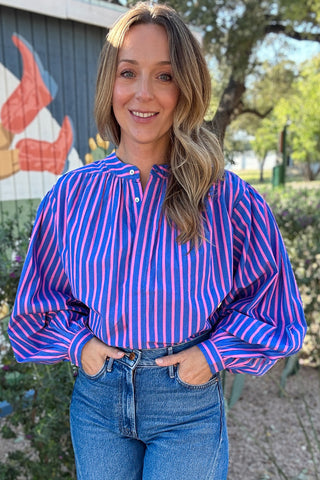 Women's pink and blue striped button-down top with a statement scarf neckline and relaxed fit, styled with high-waisted denim at Cotton & Cashmere in Blanco, Texas.