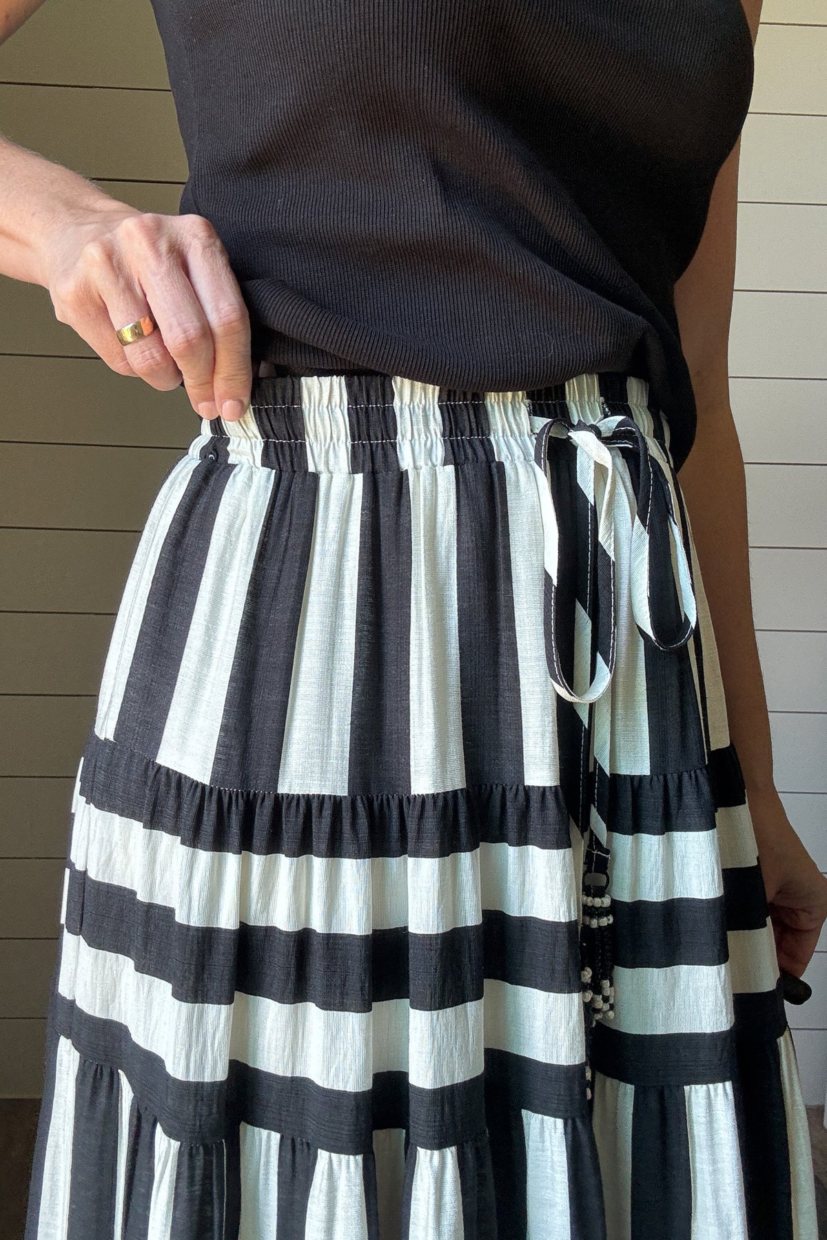 Bold, breezy, and ready for anything—this black and white striped maxi skirt brings playful drama to your everyday style. Lightweight and flowy with tiered layers, it moves beautifully and feels easy on. The drawstring waist with tassel ties keeps the fit flexible and comfy. It’s lined to the knee, so no worries about sheerness. Style it with a fitted tank or a tucked-in tee for a relaxed but polished look. Whether you're out shopping or headed to dinner, this skirt gives you just the right mix of classic a