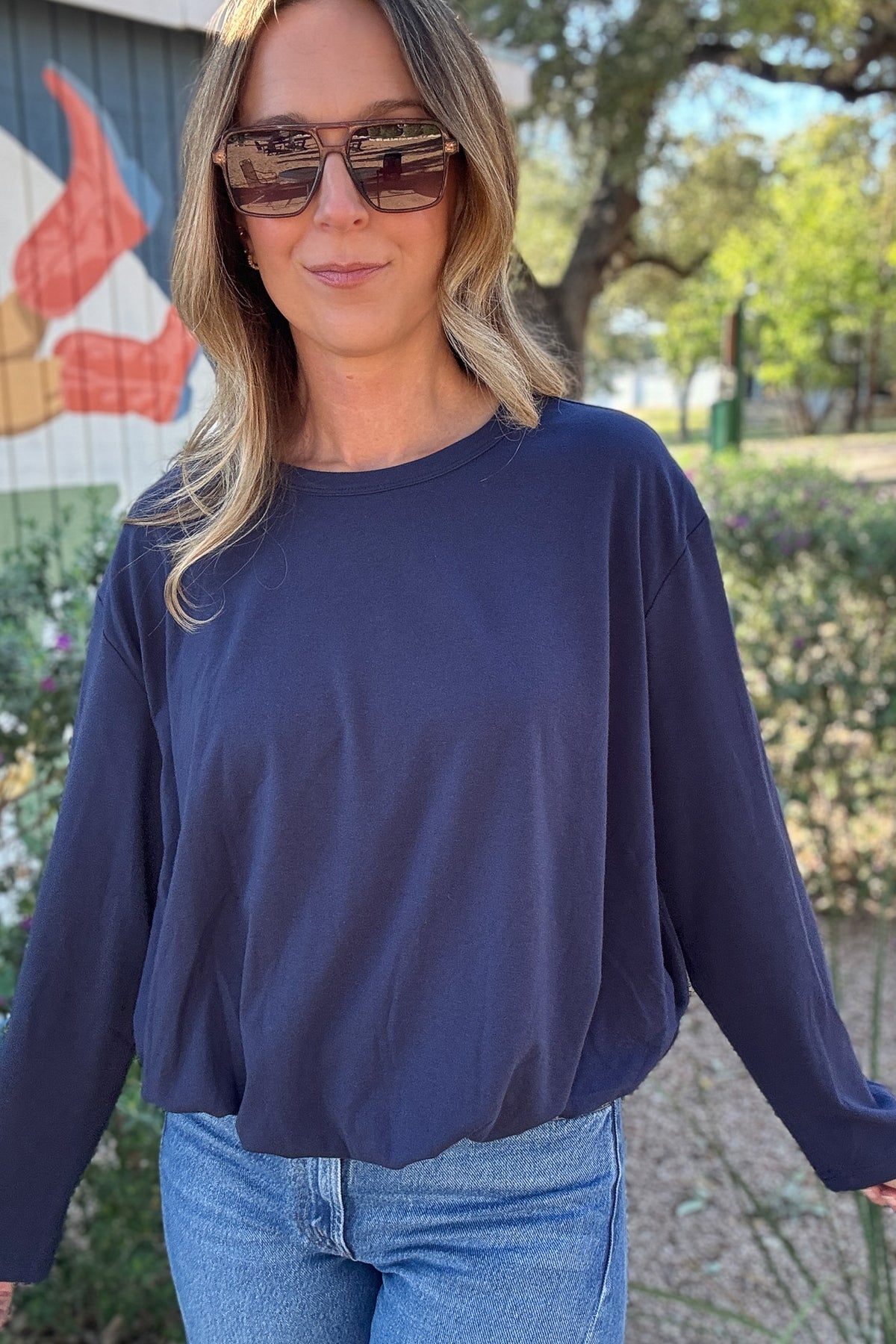 Solid navy blue long sleeve women's top with dropped shoulders, a classic crew neckline, and a relaxed, slightly cropped silhouette.