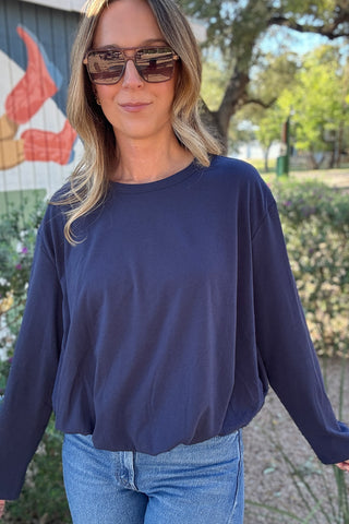Solid navy blue long sleeve women's top with dropped shoulders, a classic crew neckline, and a relaxed, slightly cropped silhouette.