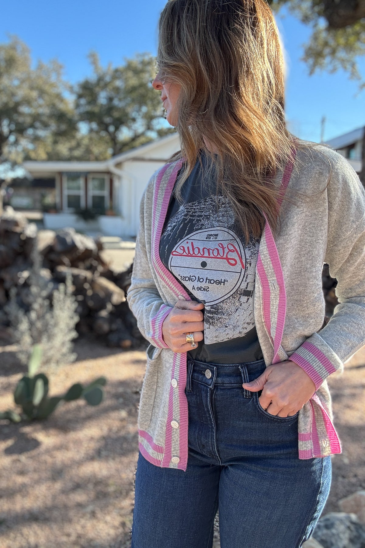 Luxury meets everyday ease in this 100% cashmere cardigan. The soft heather grey body is accented with bold pink and grey striped trim, giving a classic silhouette a modern pop of color. Lightweight yet warm, it’s the perfect piece for layering — an elevated staple for effortless clothing and everyday wear.
