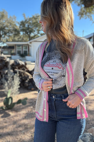 Luxury meets everyday ease in this 100% cashmere cardigan. The soft heather grey body is accented with bold pink and grey striped trim, giving a classic silhouette a modern pop of color. Lightweight yet warm, it’s the perfect piece for layering — an elevated staple for effortless clothing and everyday wear. Women's fashion boutique Blanco Texas