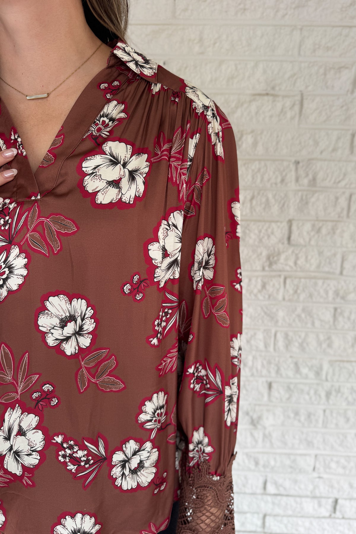 A floral blouse with a refined touch. Designed in a warm brown base with bold contrast blooms and lace-trimmed sleeves, this top adds an elevated feel to everyday dressing. Lightweight with subtle drape, it pairs easily with denim or trousers and works well for both weekday and weekend.