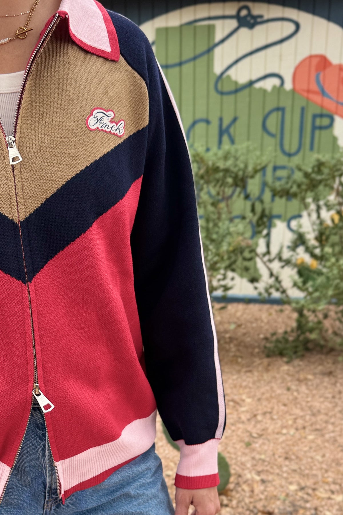close up of FRNCH women’s colorblock zip sweater cardigan in red, navy, camel and pink at Cotton & Cashmere boutique in Blanco, Texas