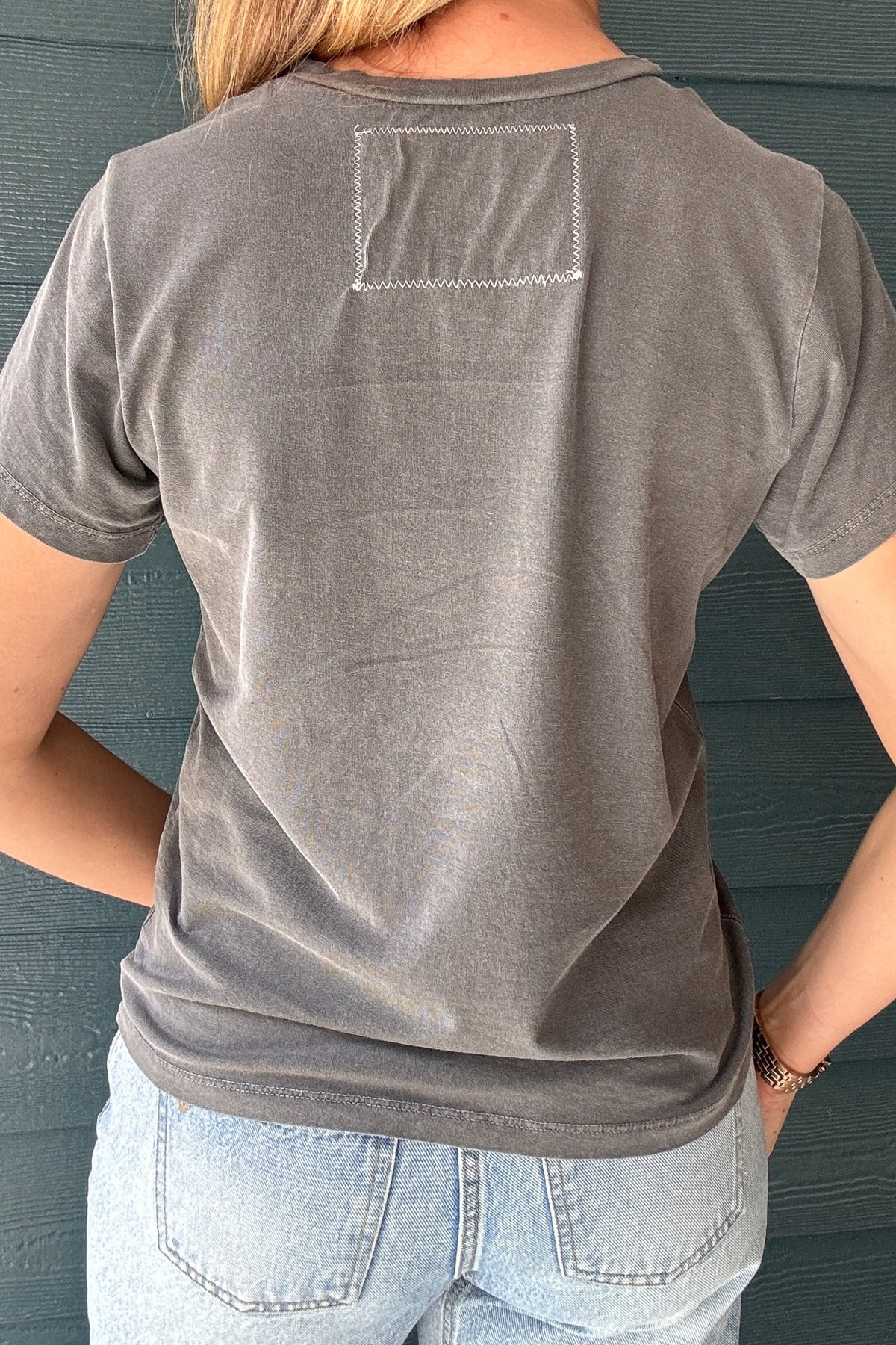 Model wearing a washed charcoal Willie Nelson cotton graphic tee by People of Leisure, available at Cotton & Cashmere in Blanco, Texas.