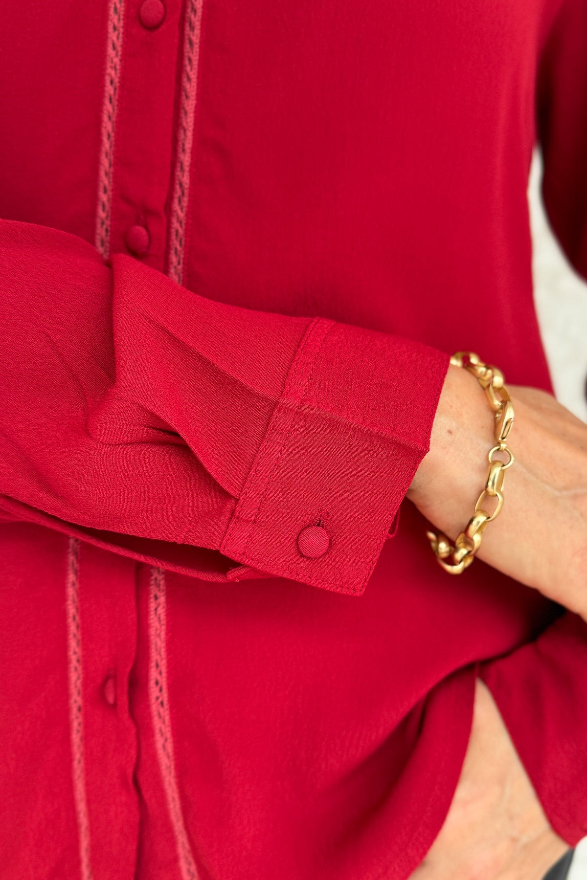 &nbsp;This rich red blouse delivers classic style with a subtle feminine touch. Designed in soft 100% viscose, it features delicate lace trim along the button placket and a flattering v-neckline with a small collar.
