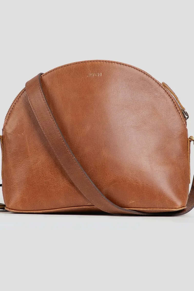 With a beautifully curved half moon silhouette, the Halfmoon Crossbody is a minimal everyday bag, designed for life on the go. Handcrafted from recycled leather with a removable, adjustable strap that can be worn as a clutch, crossbody or simply carried comfortably over the shoulder.