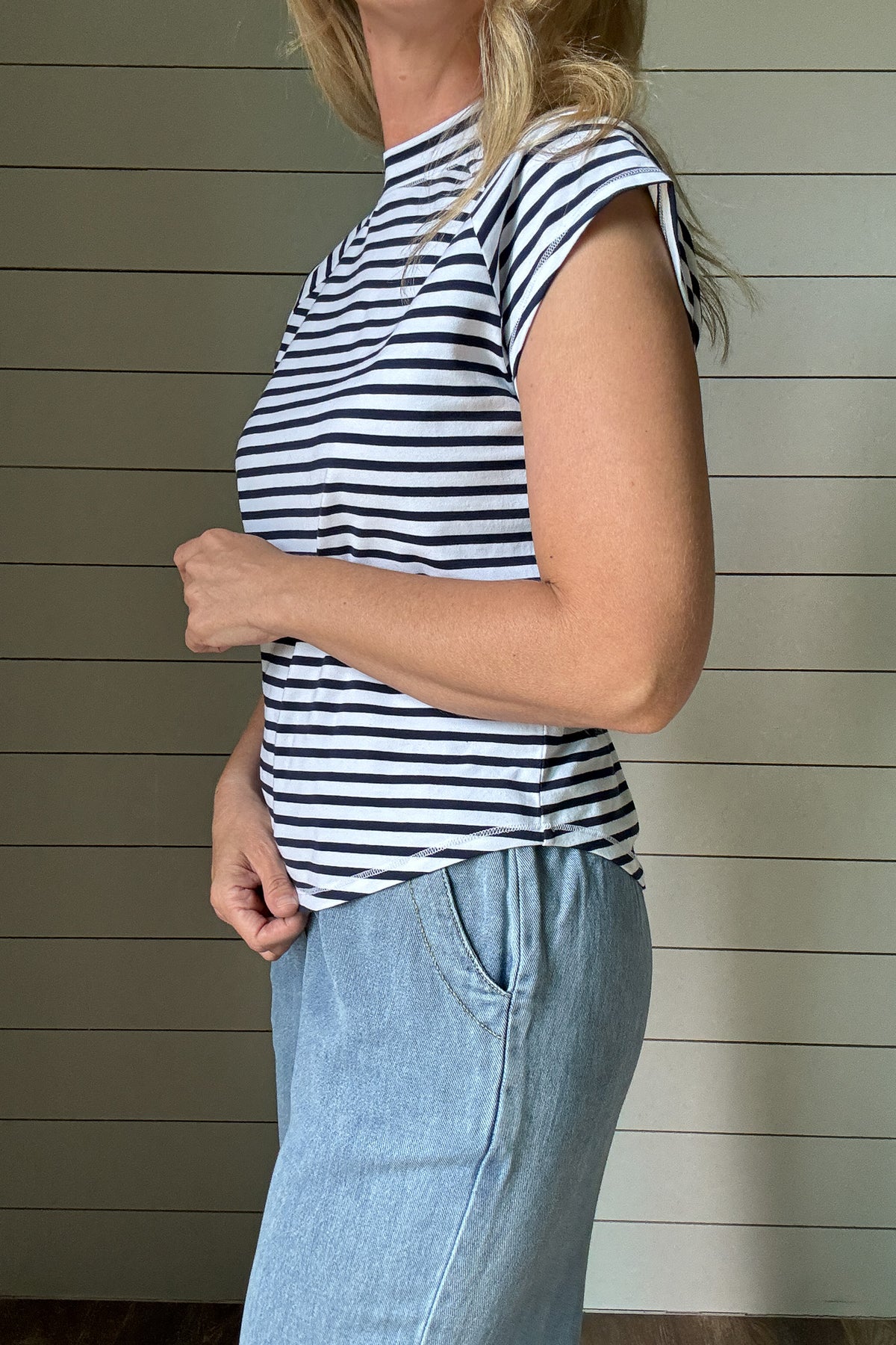 &nbsp;This striped high neck tee is a summer go-to. The navy and white stripe print feels fresh and classic, while the high neckline adds a modern touch. Made for everyday wear, it’s cut with a relaxed fit and a swooping hemline that gives it an easy, flattering shape. Whether you're heading out or staying casual, this tee is one you'll keep reaching for.